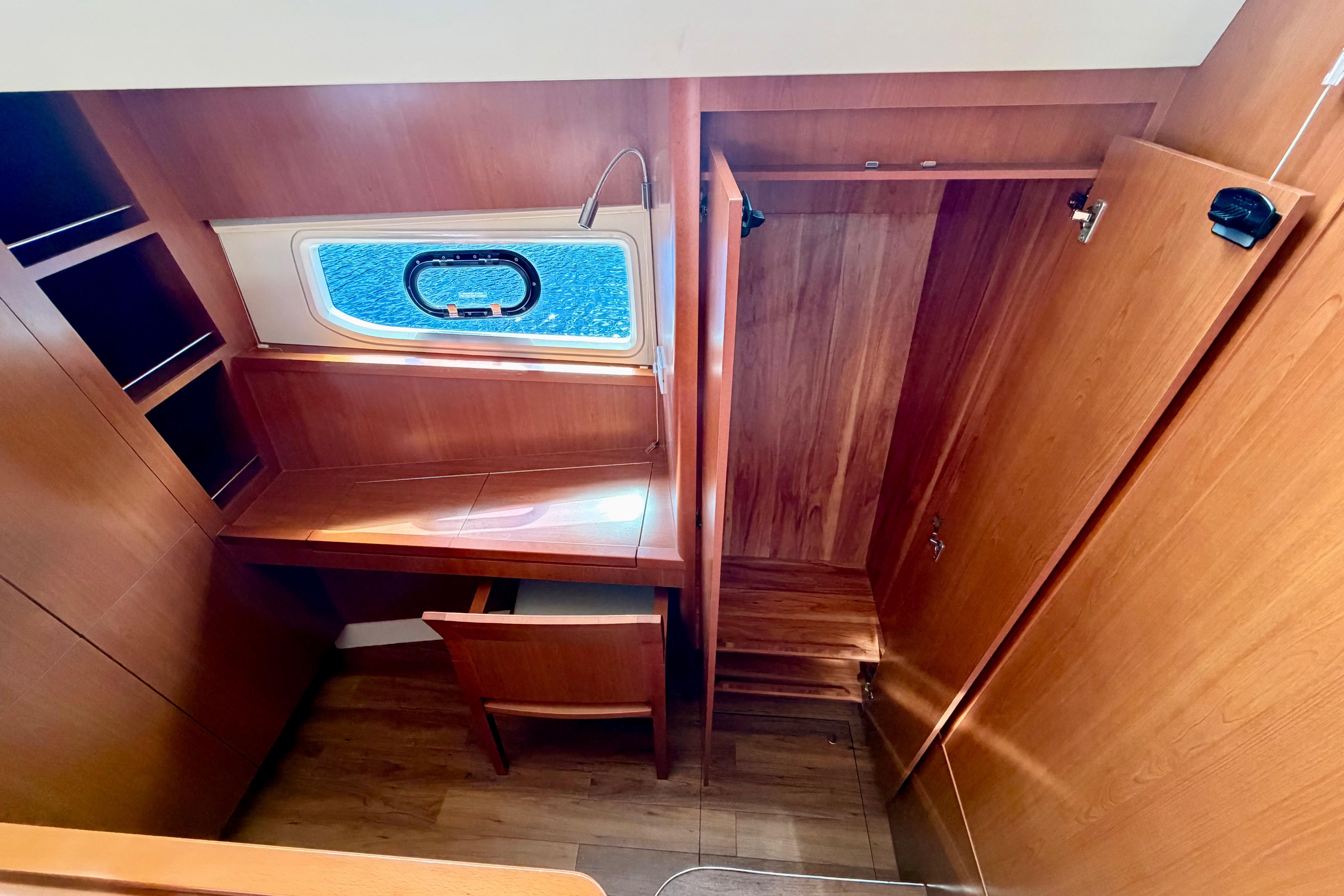 2017 Aquila 44 Yacht interior with wooden desk, chair, and window view.