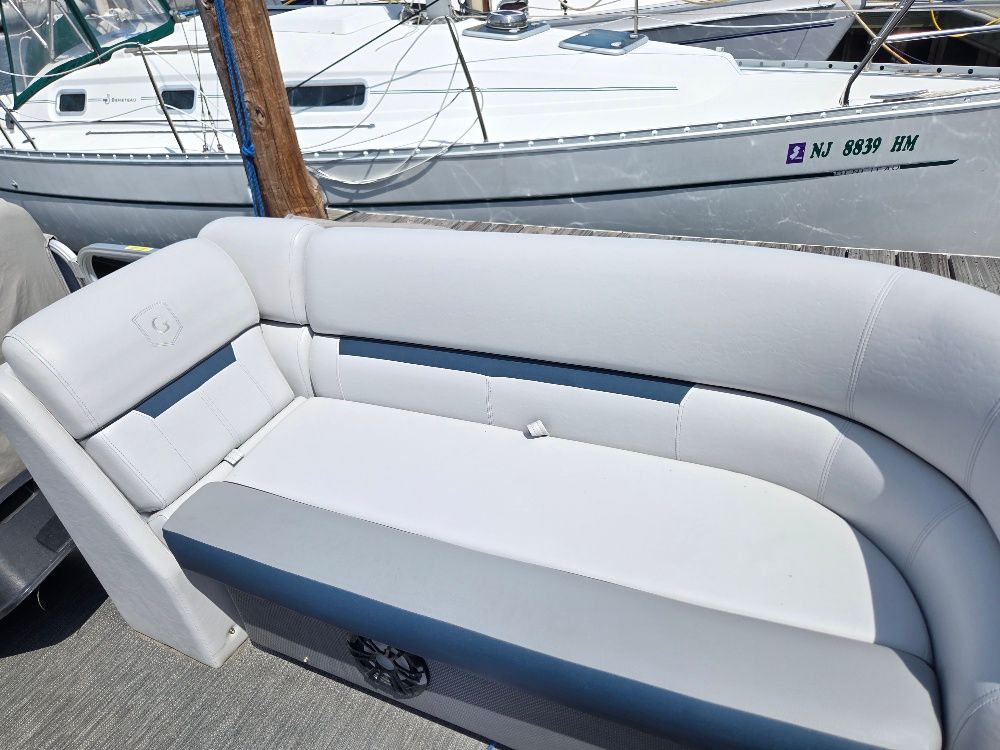The image shows a white bench seat on a boat docked at a marina.