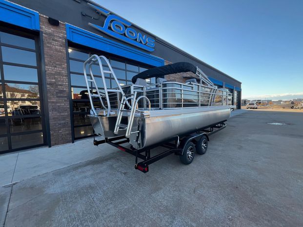 2025 Landau Atlantis 23C Cruise pontoon boat outside a store.