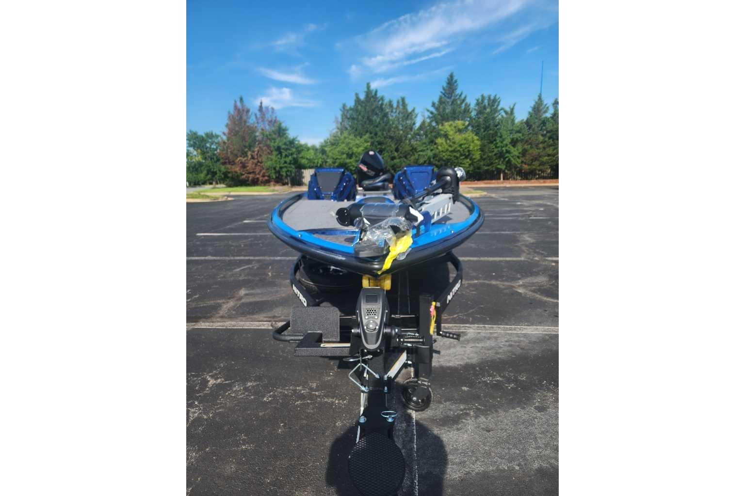 2025 Nitro Z21 XL boat in parking lot, blue and gray design, clear sky background.