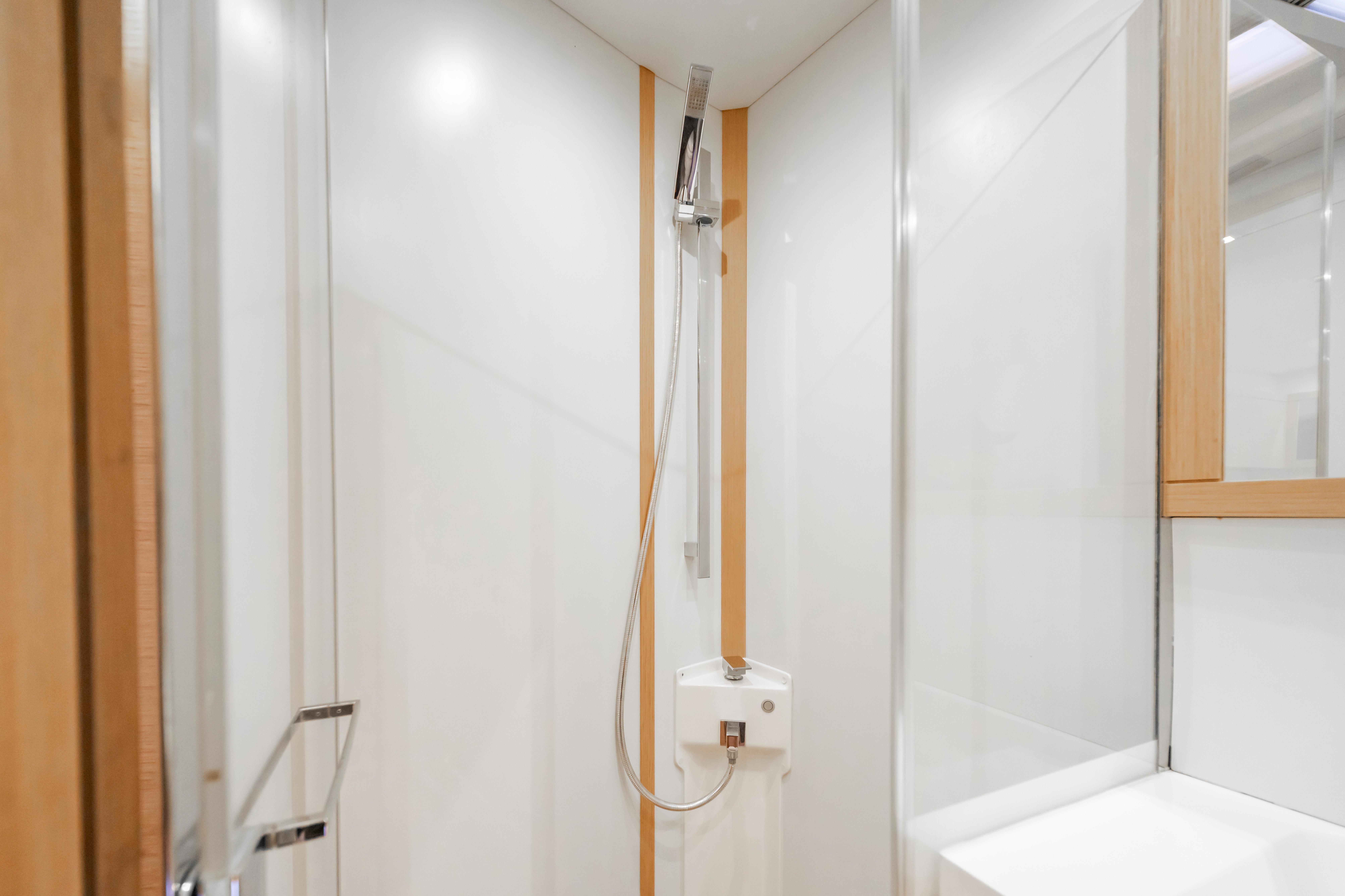 Modern shower area in 2016 Grand Soleil 58 yacht, featuring sleek design and wooden accents.