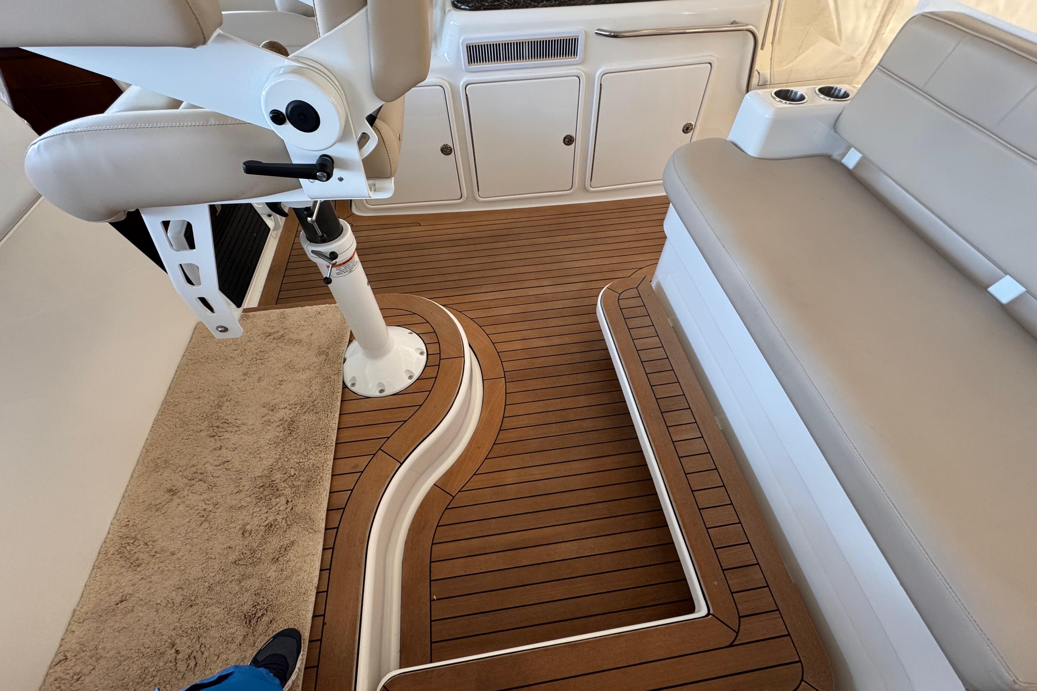 Interior of 2013 Cabo 44 Hardtop Express with teak flooring and beige seating.