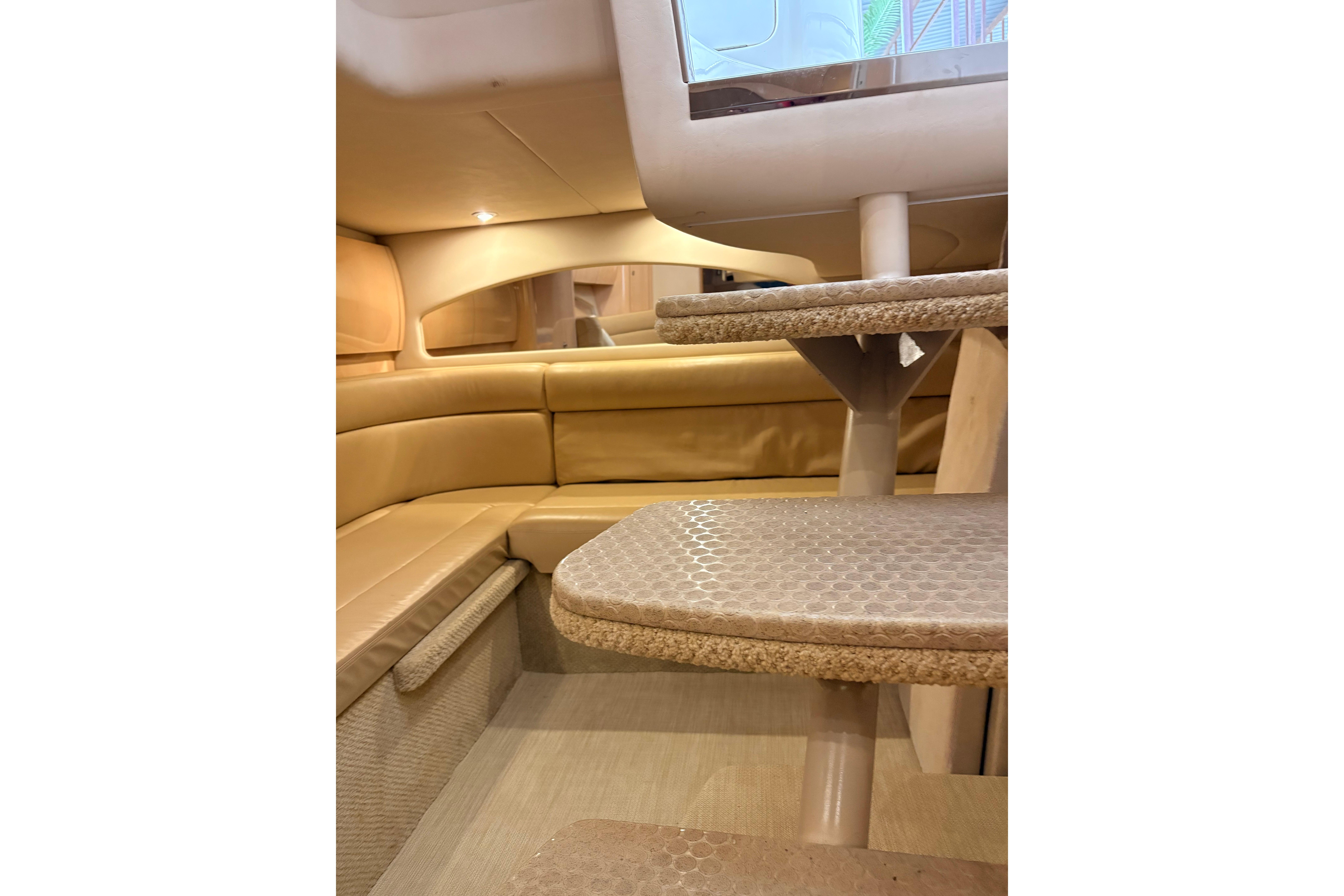 Interior of 2004 Sea Ray 360 Sundancer with beige seating and carpeted steps.