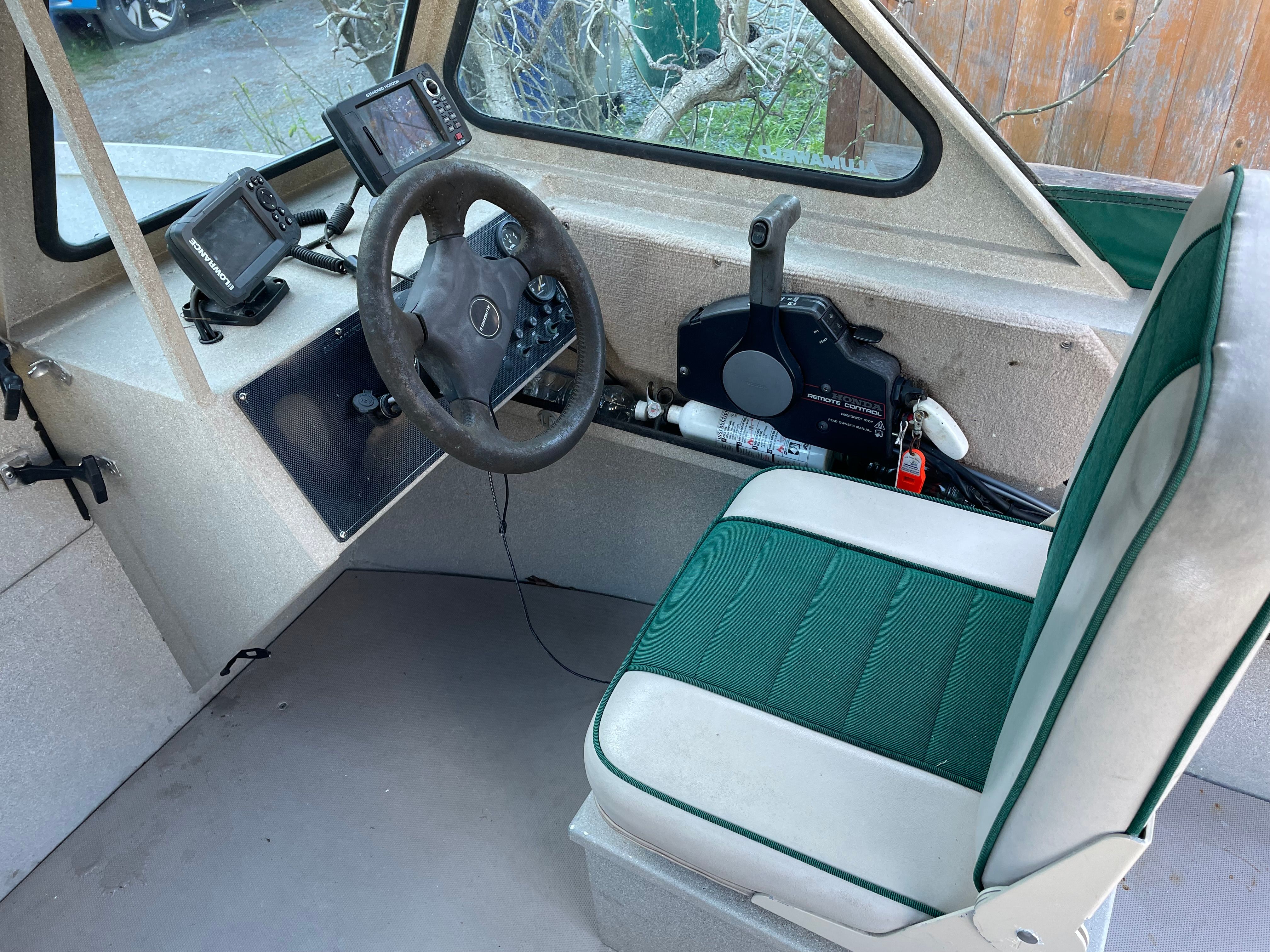 Interior of a 2001 Alumaweld Stryker boat with steering controls and seat.