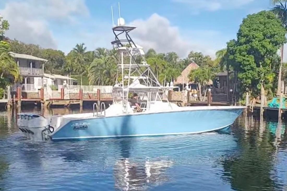2014 SeaHunter 45 Tournament boat on calm water near a dock, surrounded by trees.
