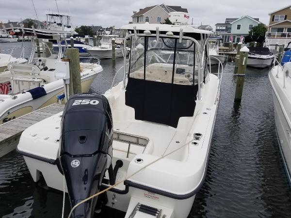 2011 Boston Whaler 235 Conquest boat docked in a marina, featuring a 250 HP engine.
