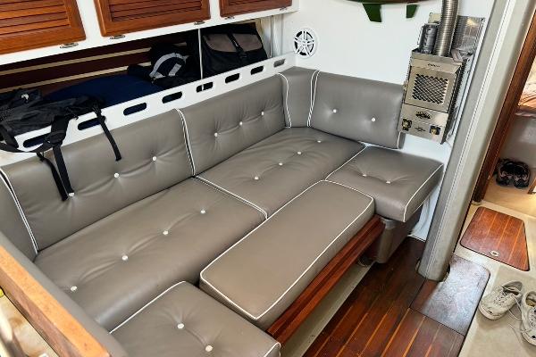 1983 O'Day 39 yacht interior with gray cushioned seating and wooden flooring.