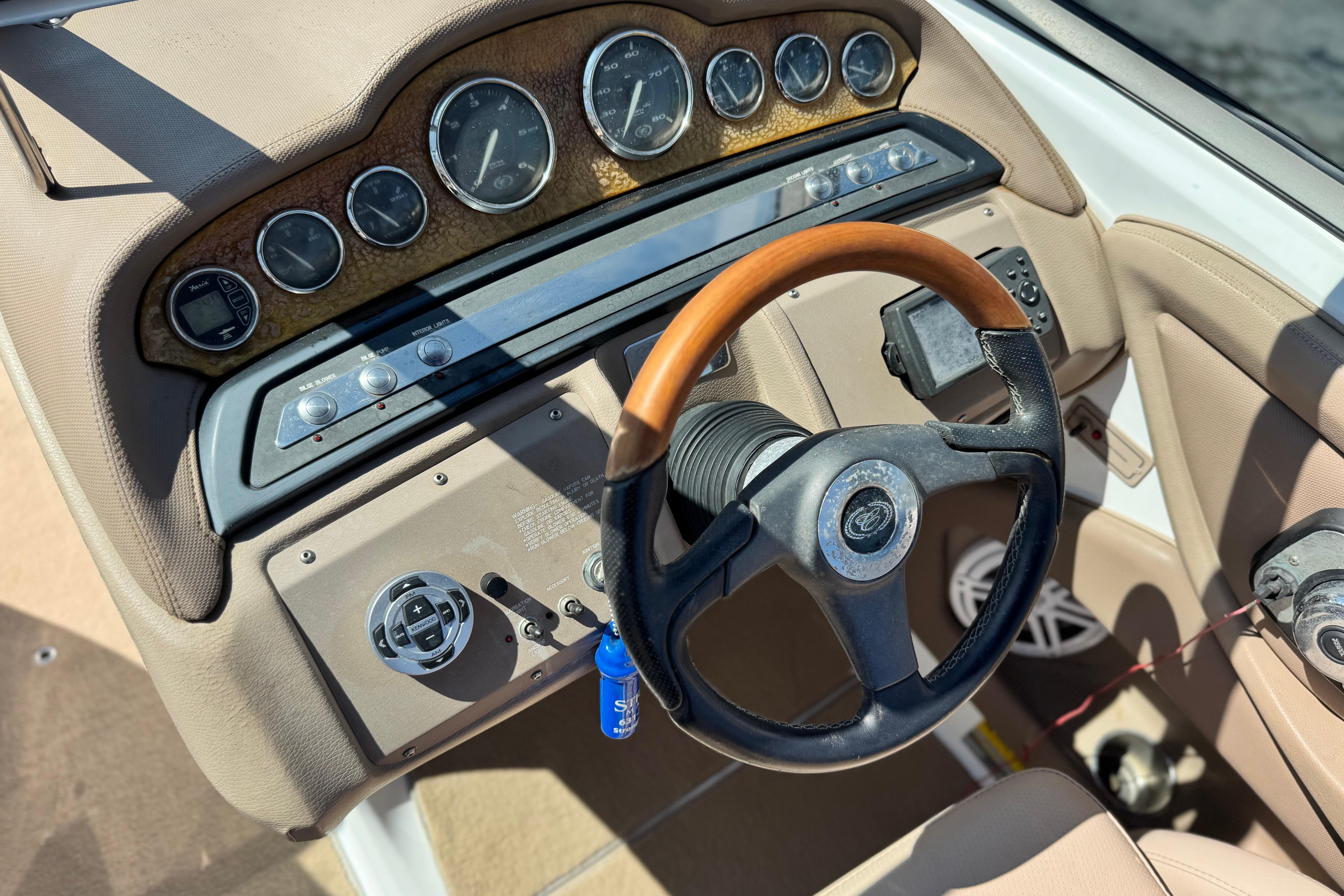 Dashboard of a 2008 Cobalt 262 boat with gauges and a wooden steering wheel.