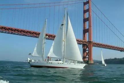 1977 Morgan Out Island 51 sailboat cruising under Golden Gate Bridge.