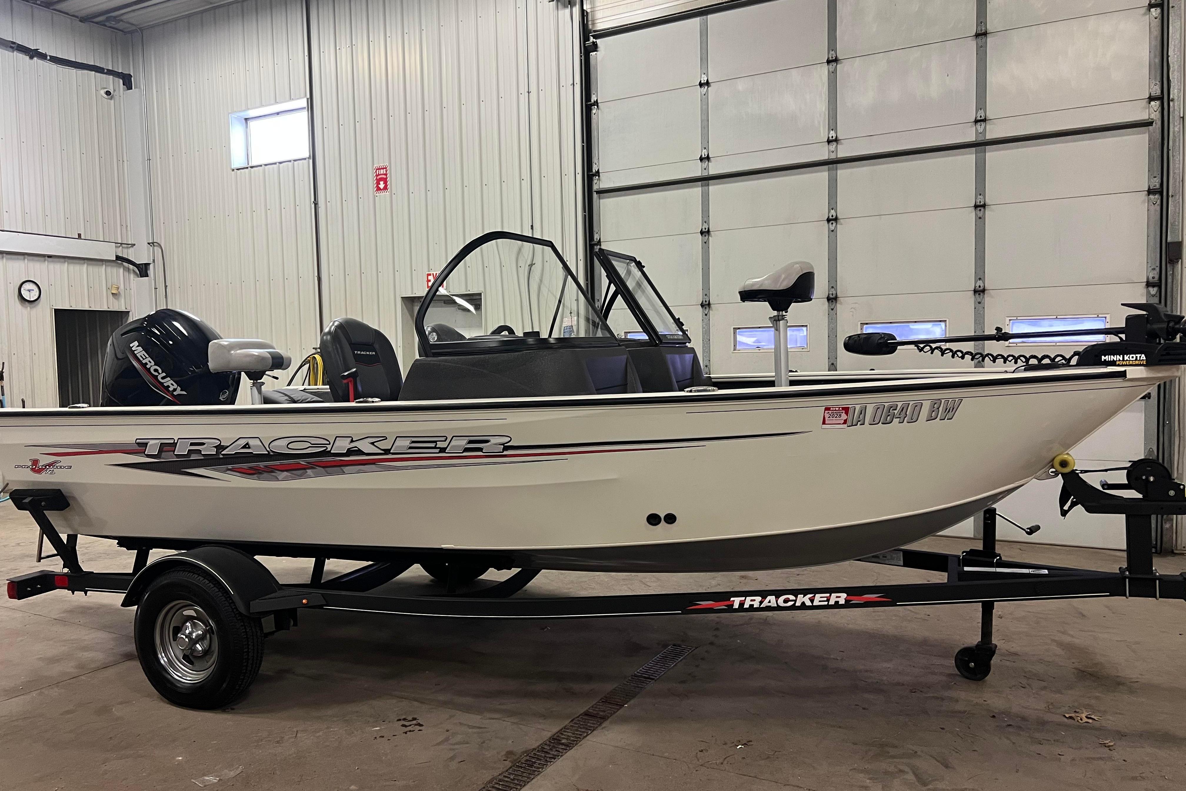 2022 Tracker Pro Guide V-16 WT boat in a garage, on a trailer.
