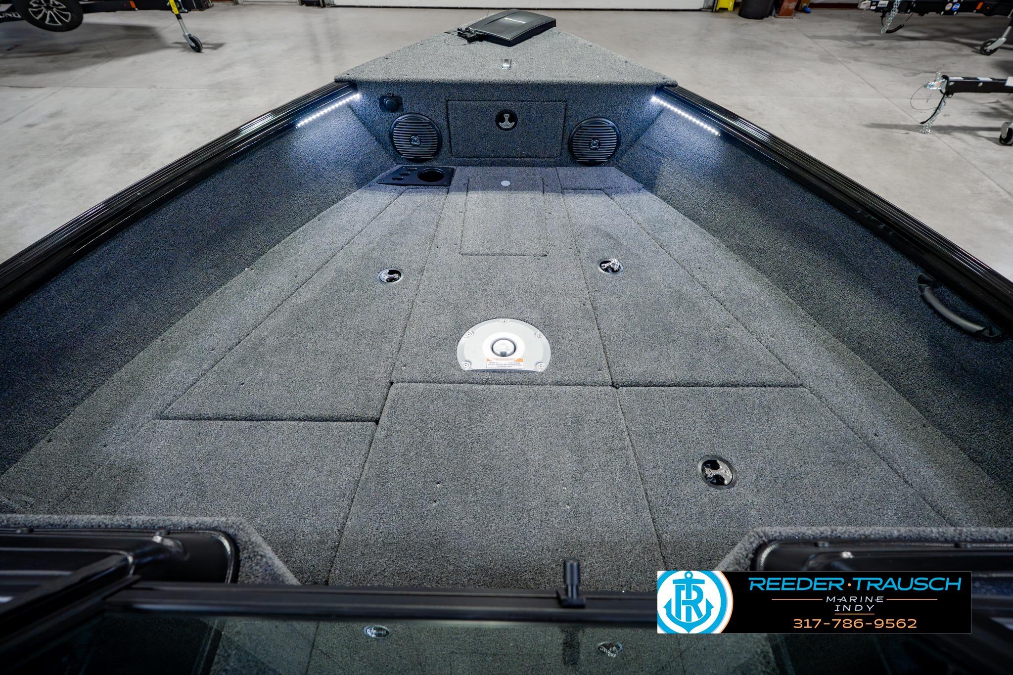 2026 Lund 1875 Impact XS boat interior with carpeted deck and storage compartments.