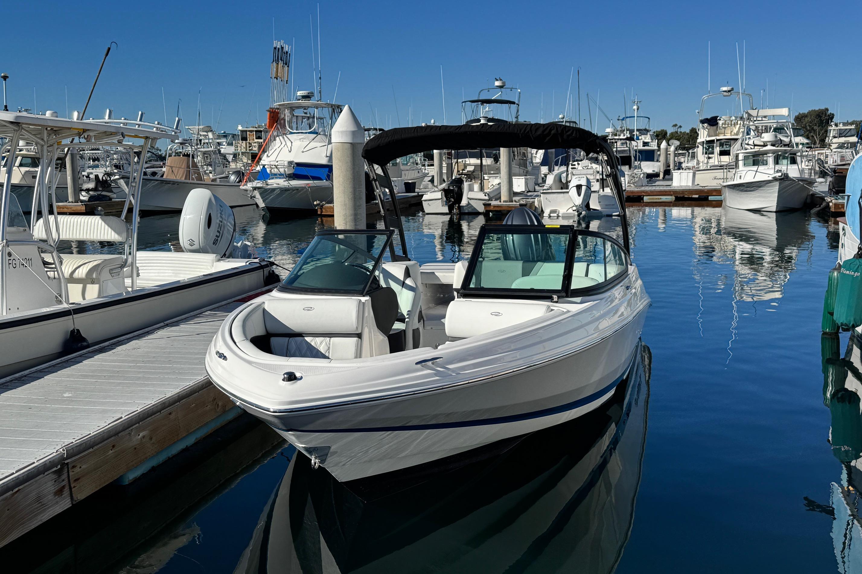 2026 Regal 21 OBX boat docked in a marina, surrounded by other vessels.