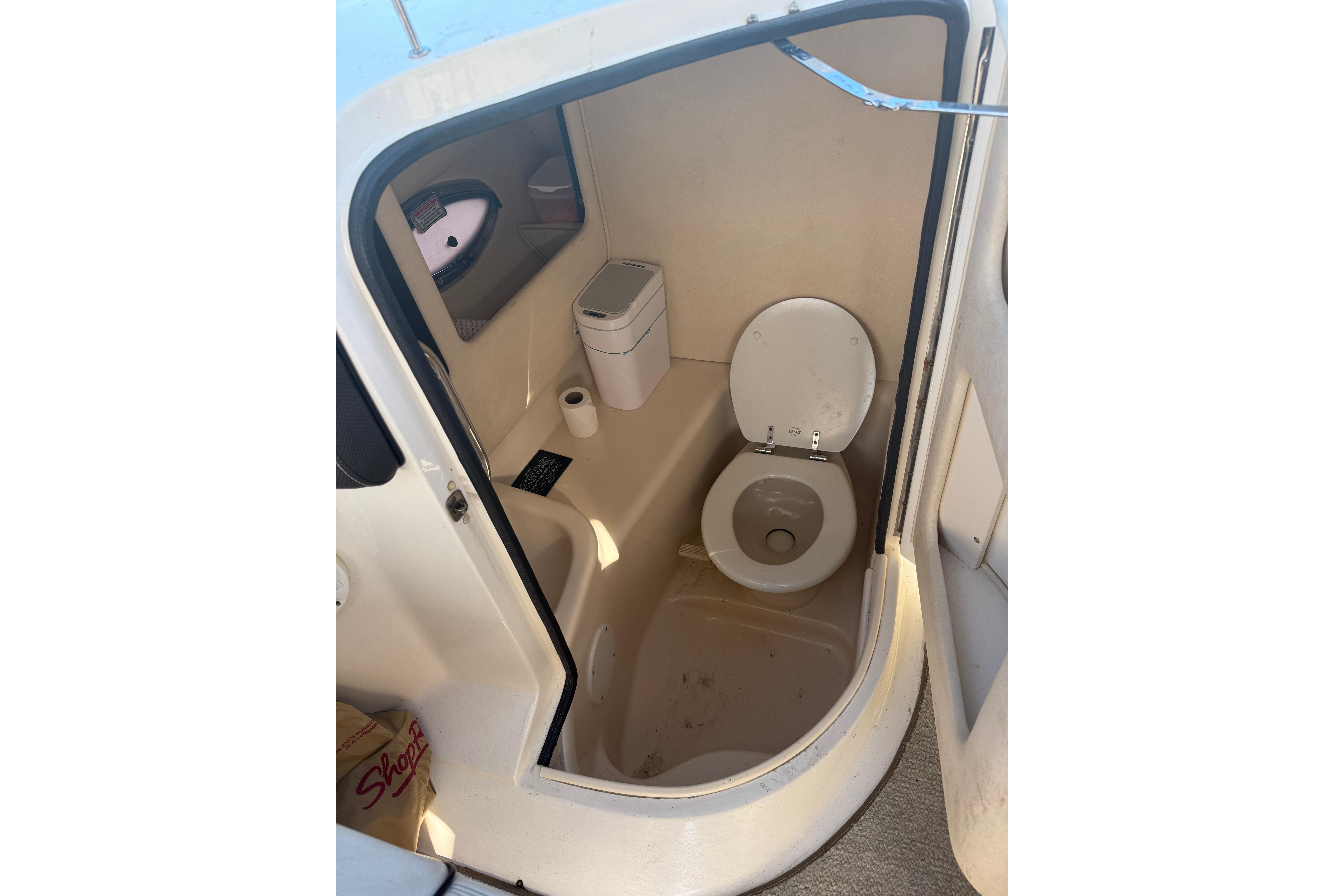 2005 Sea Ray 290 SLX boat bathroom interior with toilet and storage.