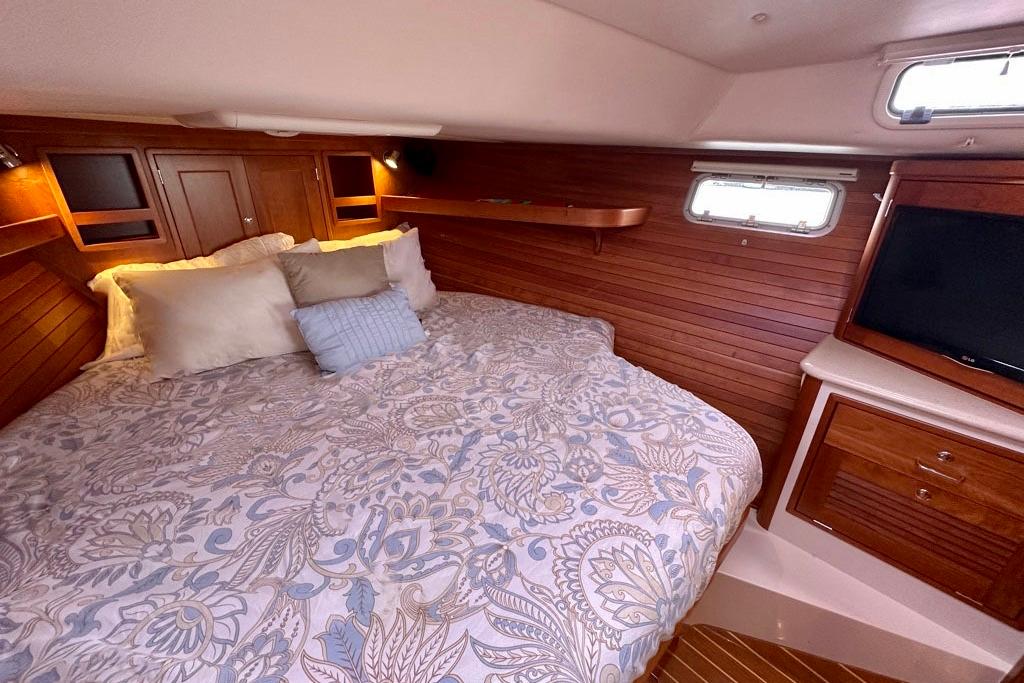 Luxurious cabin interior of 2014 MJM 40z yacht with cozy bedding and wooden accents.