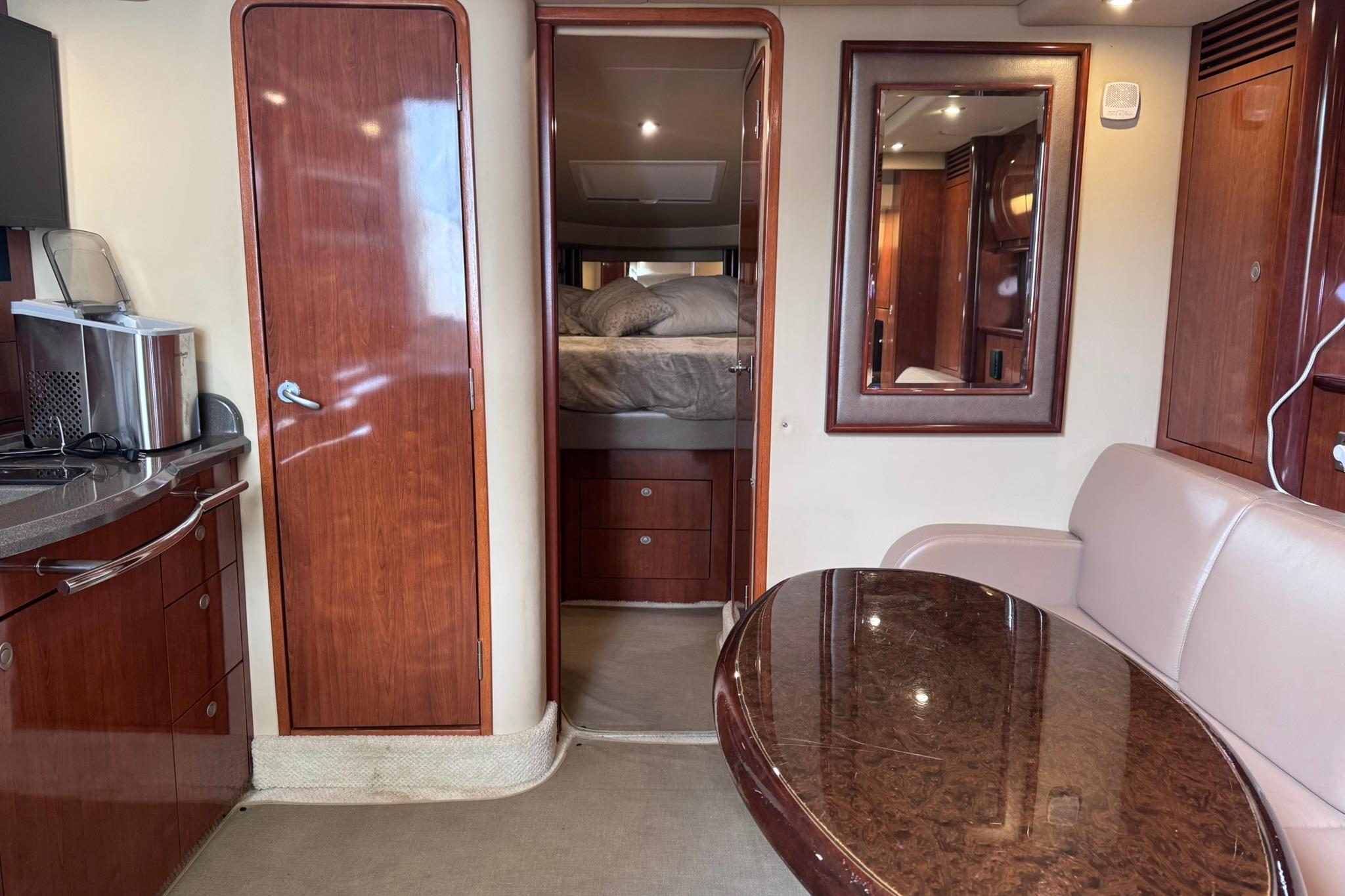 Interior of 2004 Sea Ray 390 Sundancer yacht with wood cabinetry and cozy seating area.