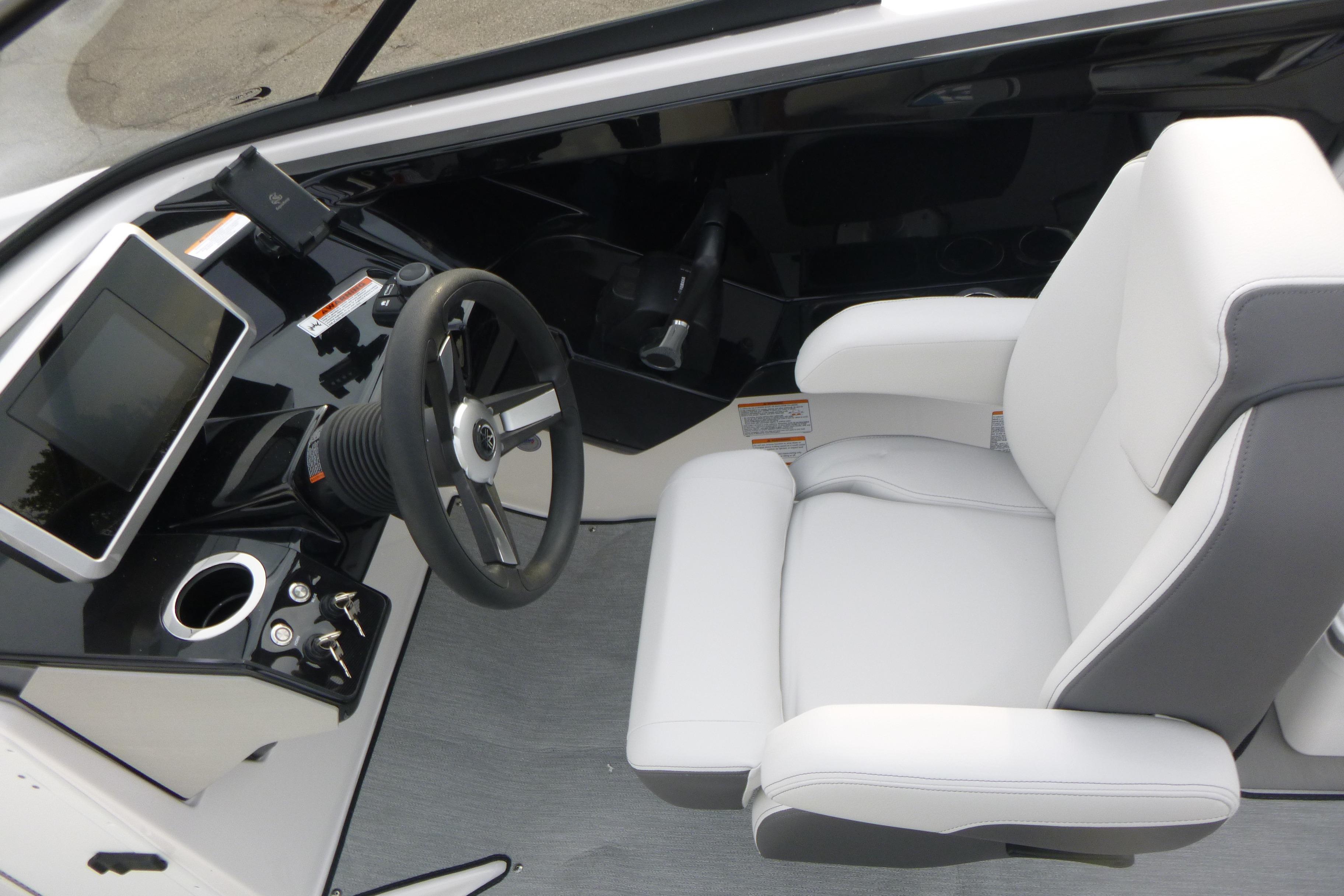 2026 Yamaha Boats AR250 cockpit with steering wheel, touchscreen, and plush captain's chair.
