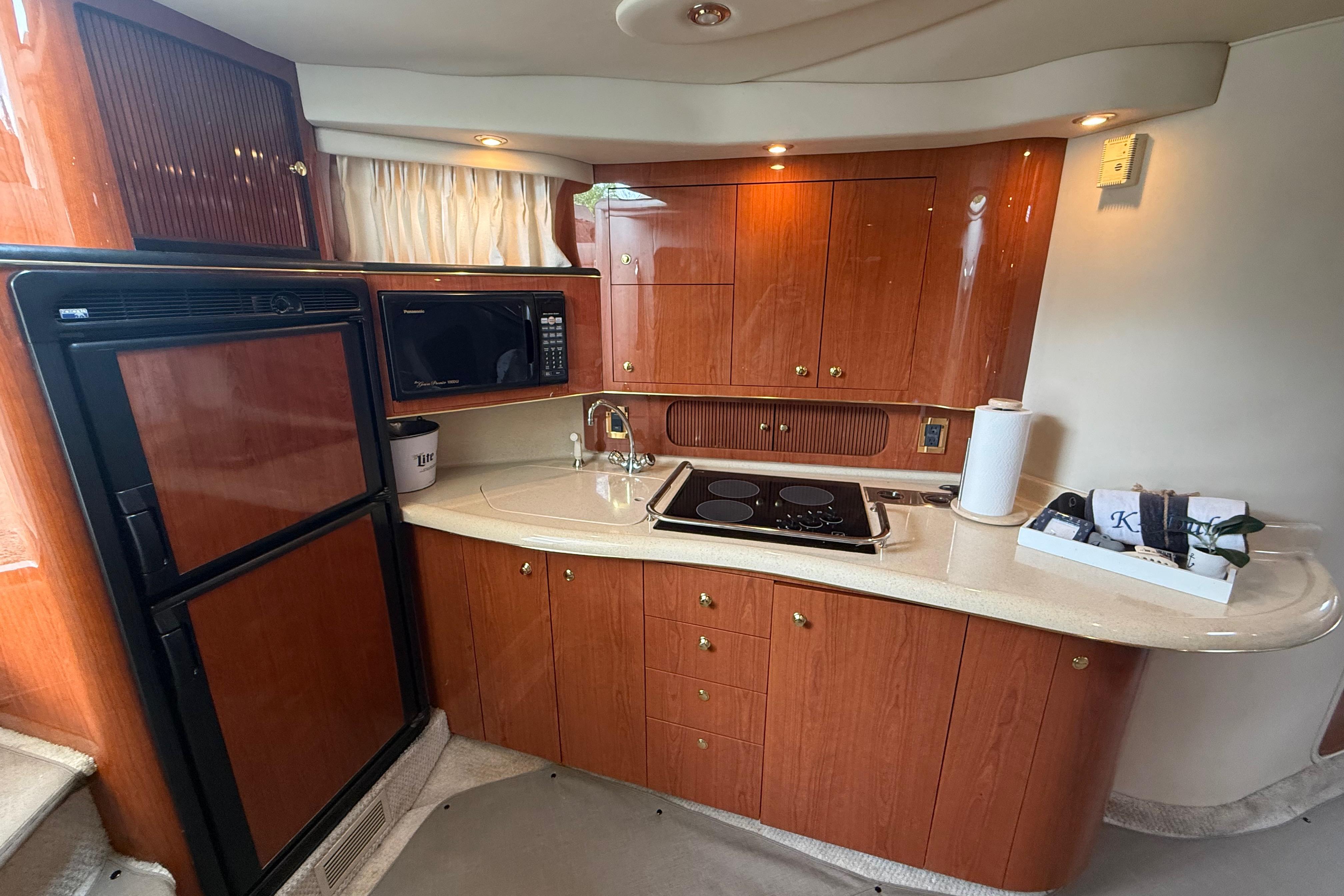 Luxurious 1998 Sea Ray Sundancer 400 yacht kitchen with wood cabinetry and modern appliances.