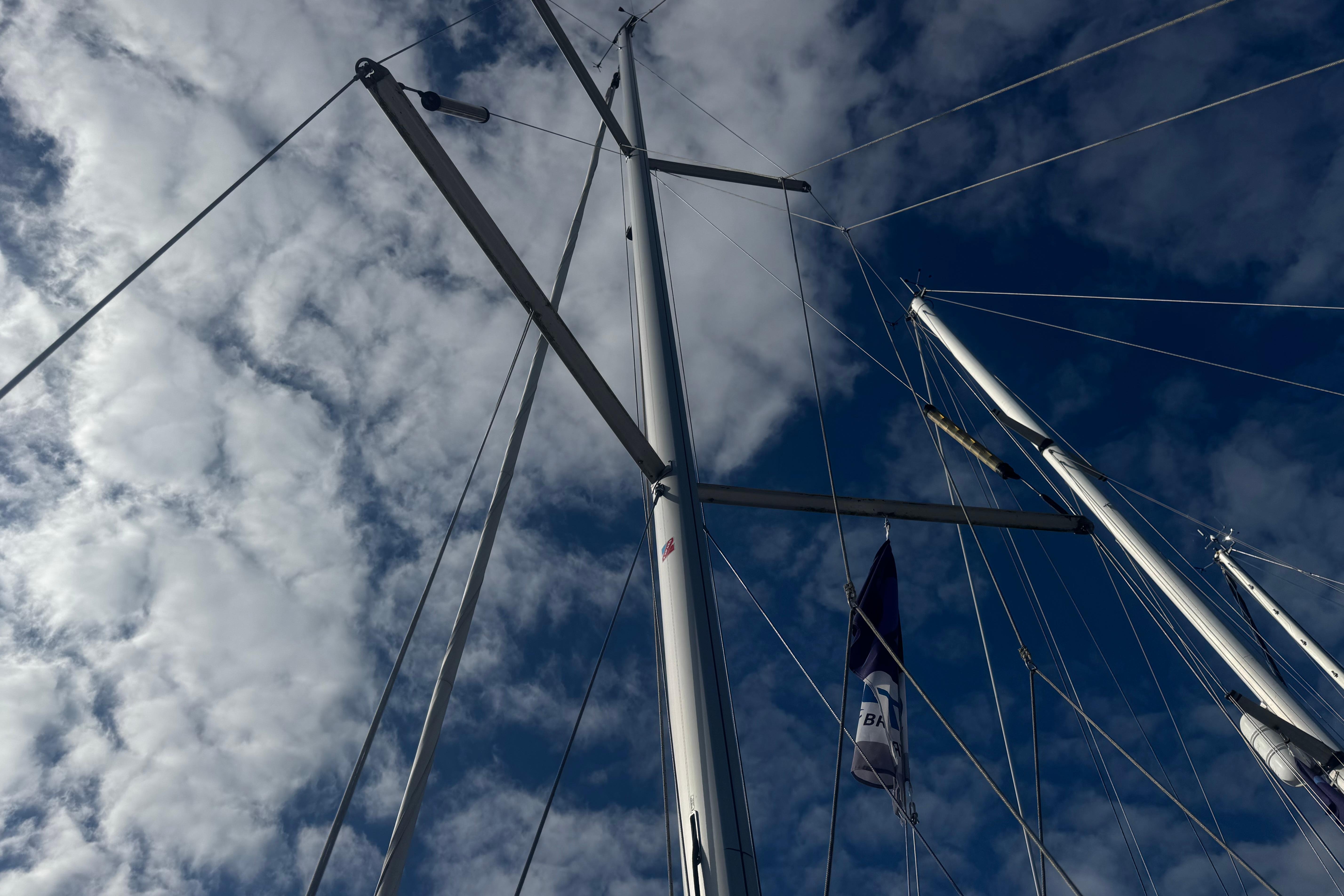 Mast and rigging of 2022 Dufour 32 sailboat against a cloudy sky.