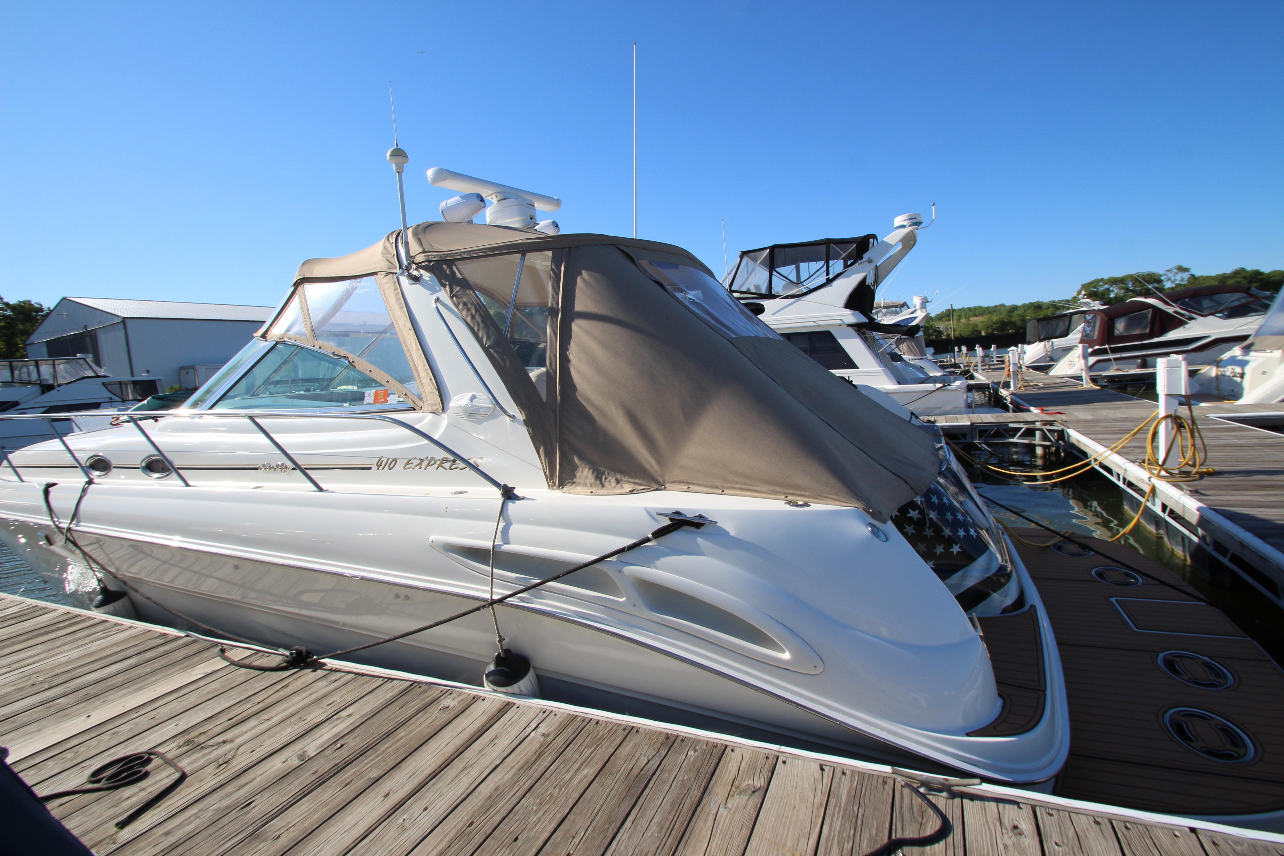 Sea Ray 410 Express Cruiser 2000 docked at marina under clear blue sky.