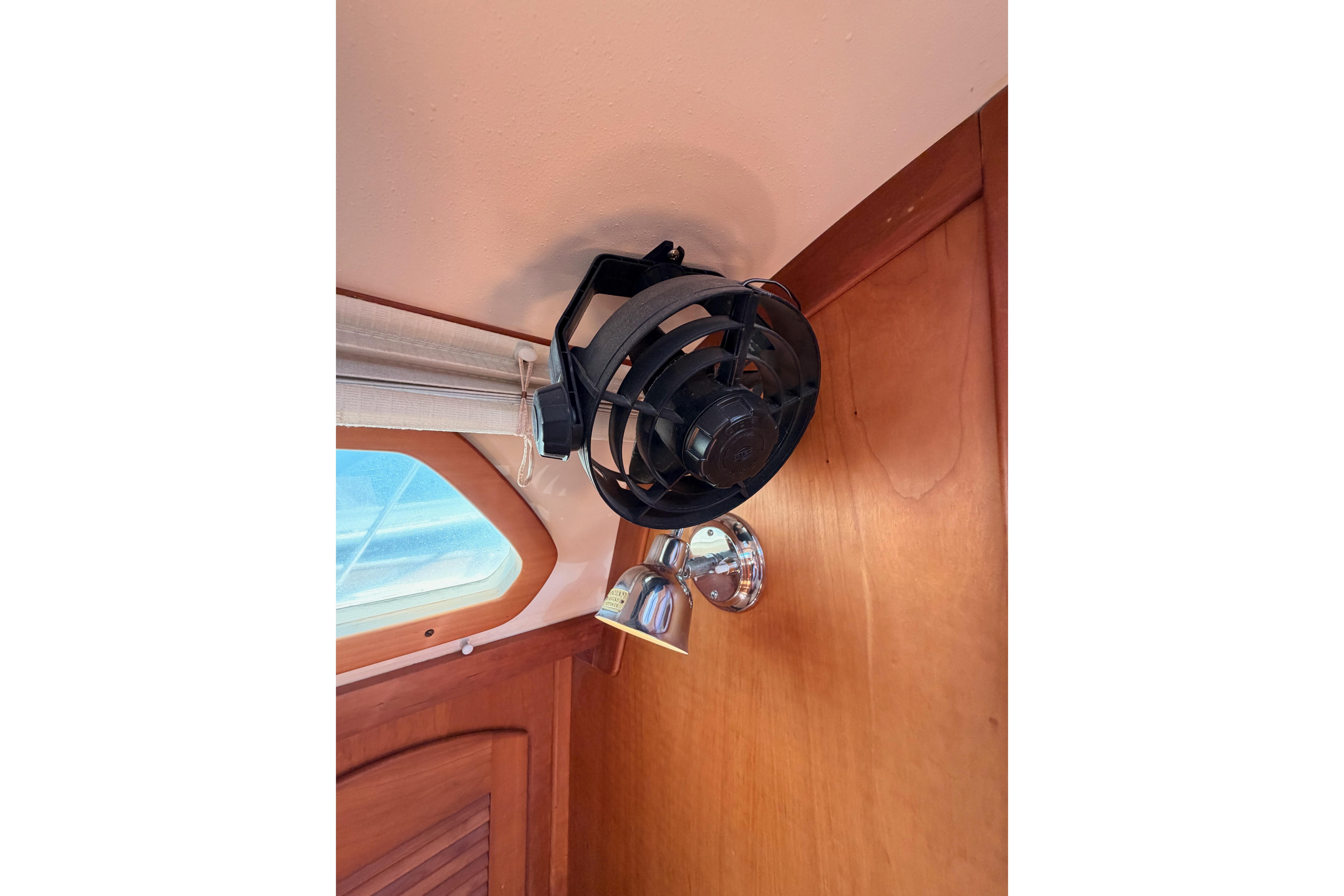 Ceiling fan and light fixture inside 2002 Sabre 362 boat cabin.