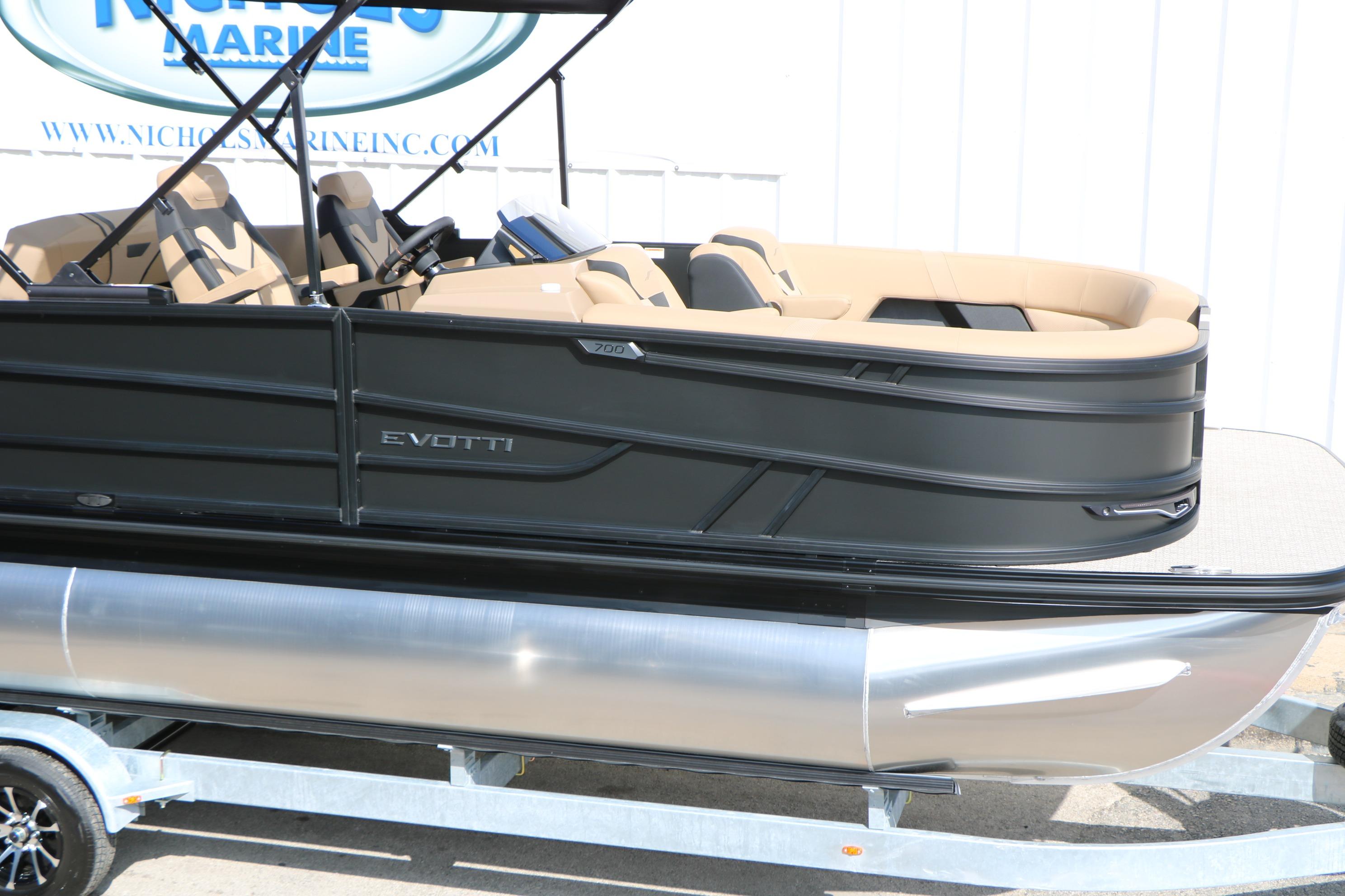 2026 Evotti 723CS pontoon boat on trailer, featuring sleek black design and tan seating.