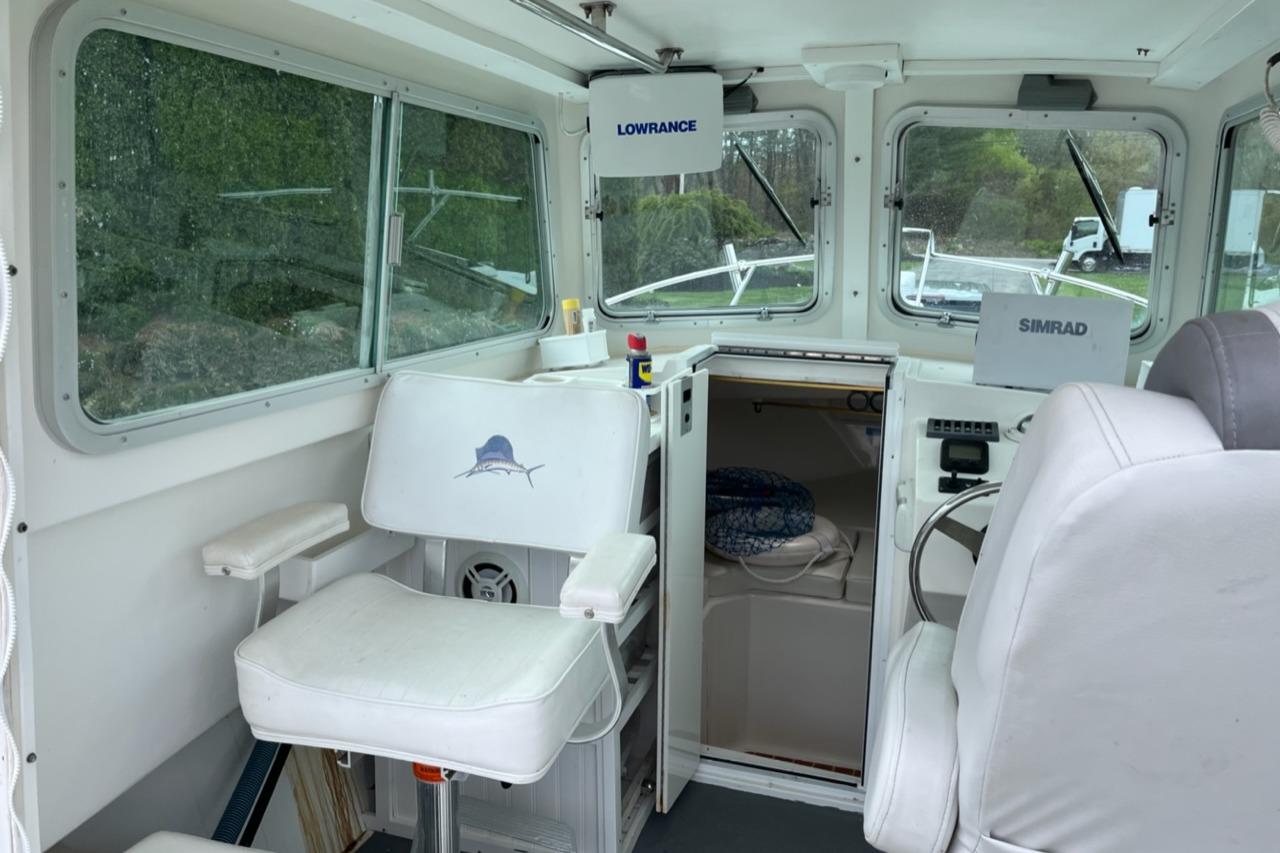 Interior of a 2012 Steiger Craft Miami boat with navigation equipment and seating.