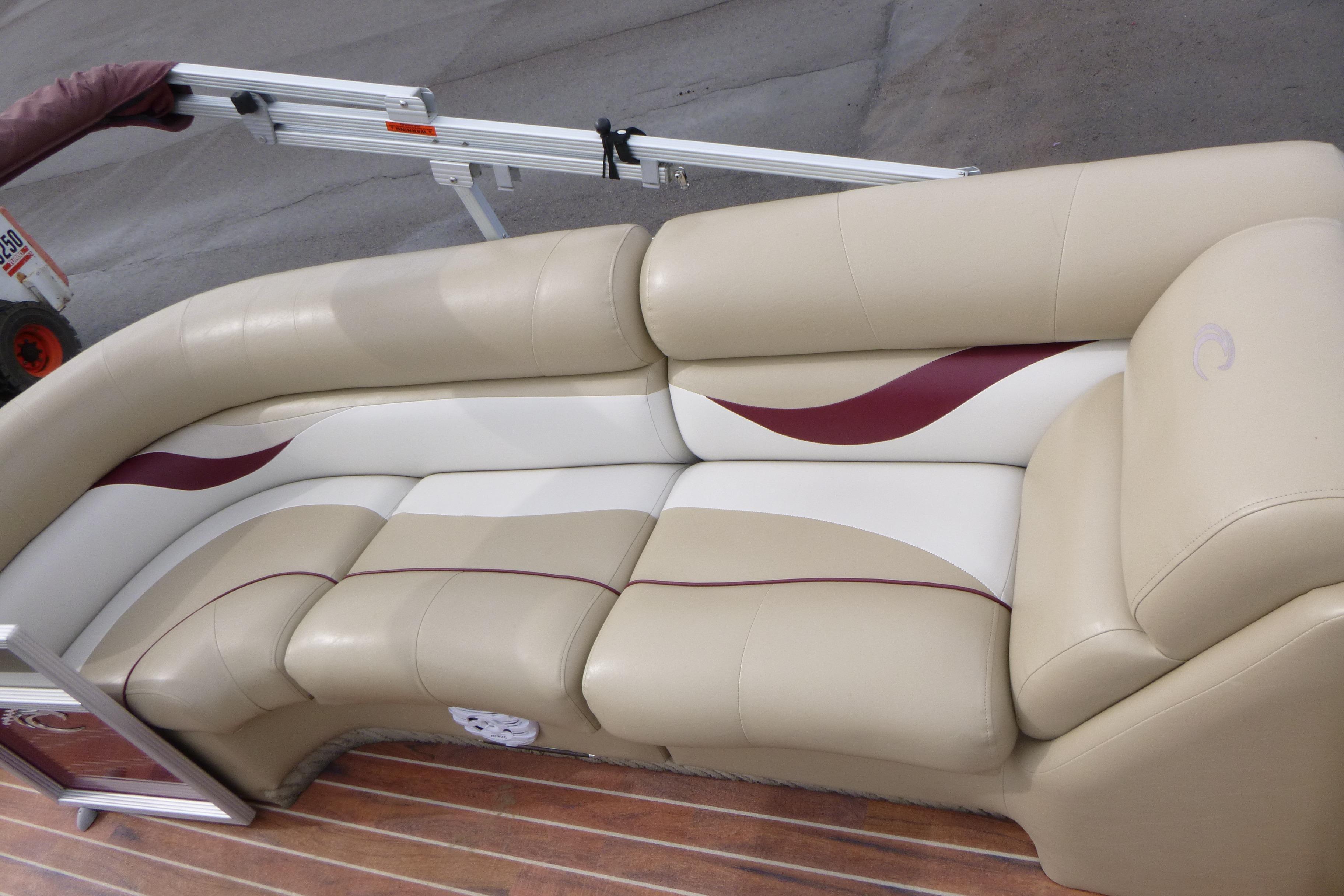Luxurious seating on a 2012 Crest 230SLR Classic boat with beige and maroon accents.