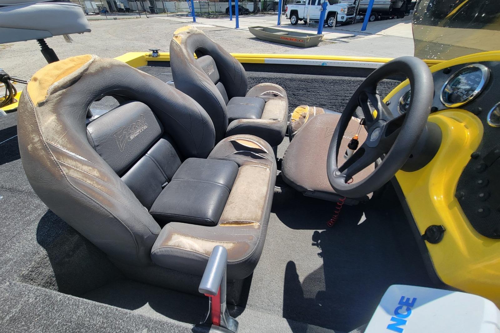 Interior of a 2011 Excel 1751 F4 boat with worn seats and steering wheel.