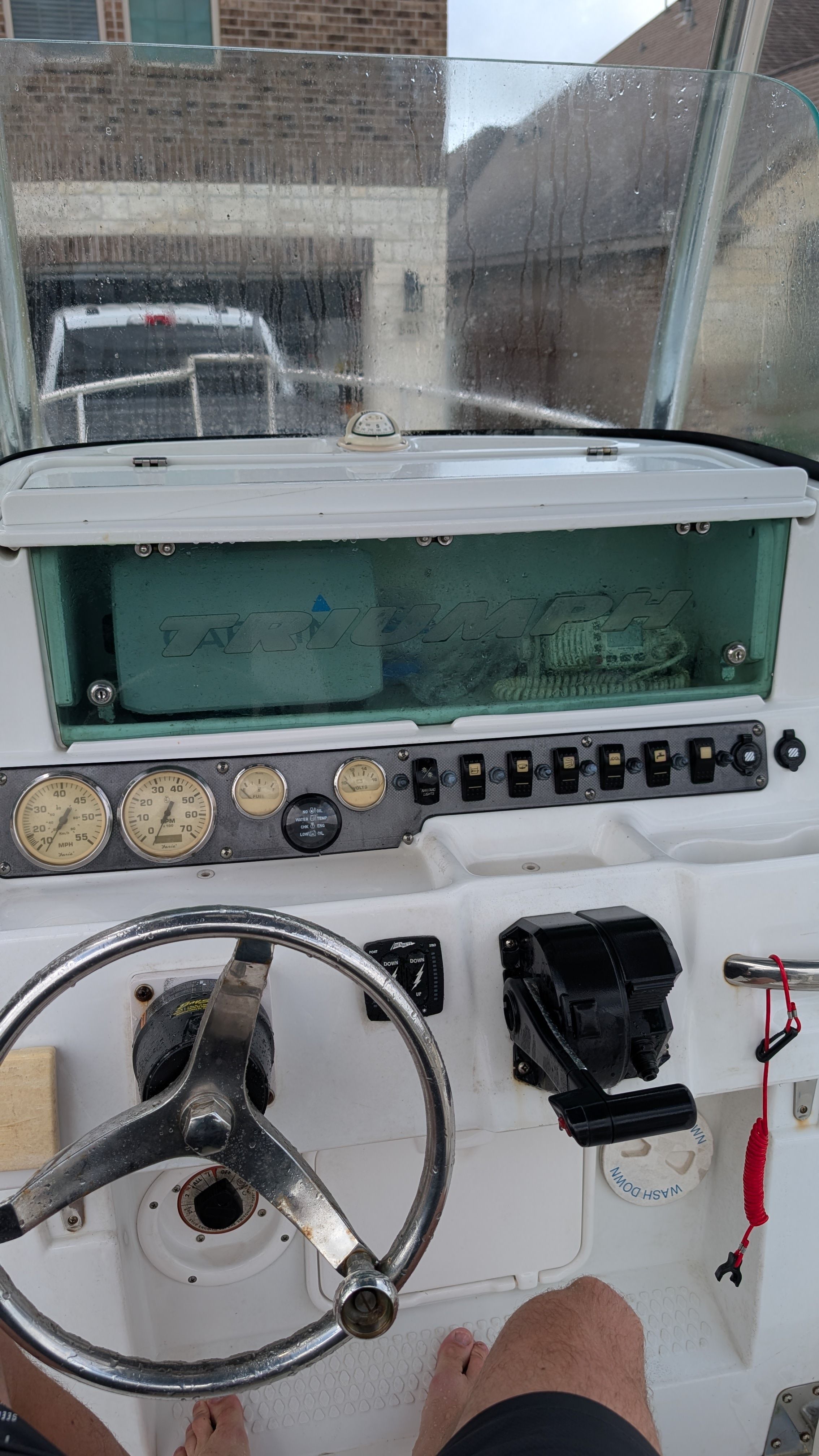 The image shows the helm of a 2007 Triumph 215 CC boat with various gauges and switches.