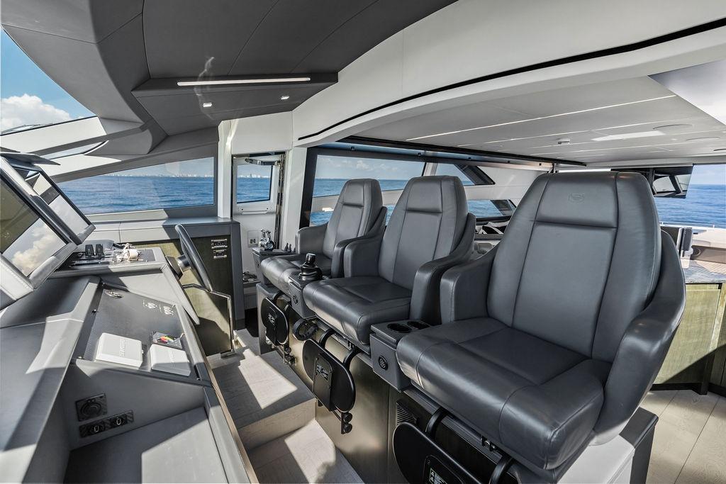 Luxurious interior of 2019 Pershing 9X yacht with modern helm and leather seating.