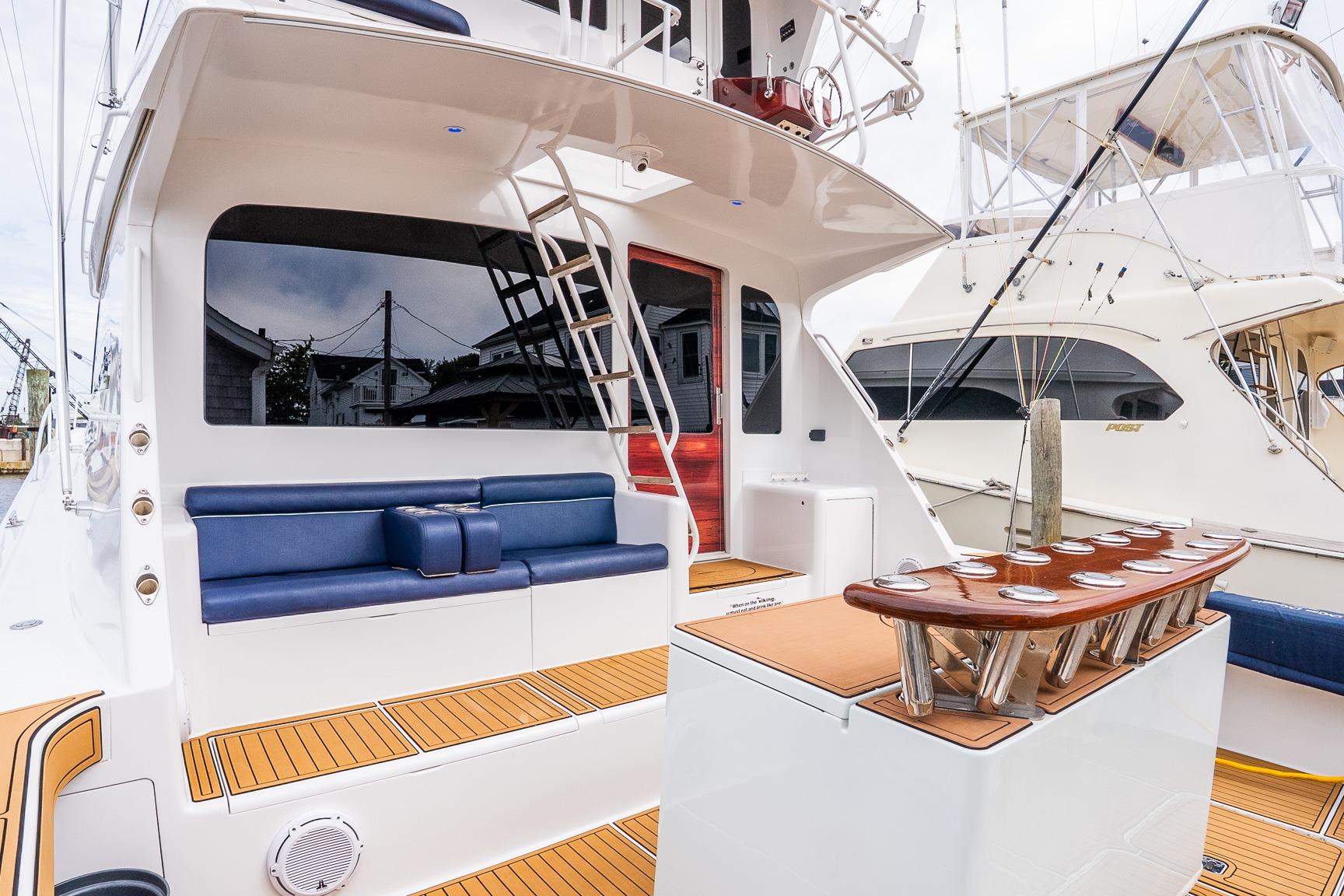 2002 Viking 61 Enclosed Bridge yacht with sleek seating and fishing rod holders.