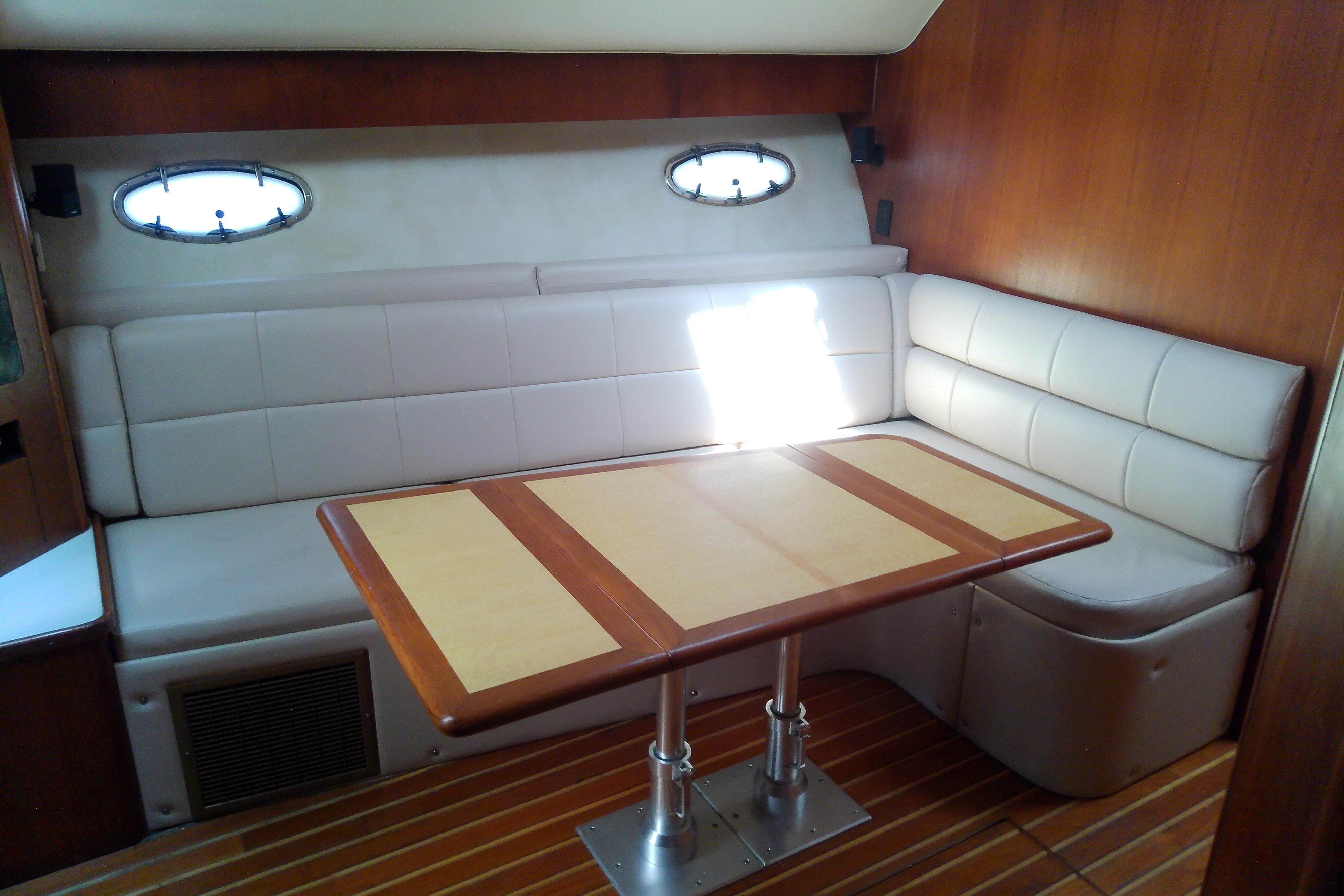 Interior of 2000 Tiara Yachts 4100 Open with cushioned seating and wooden table.