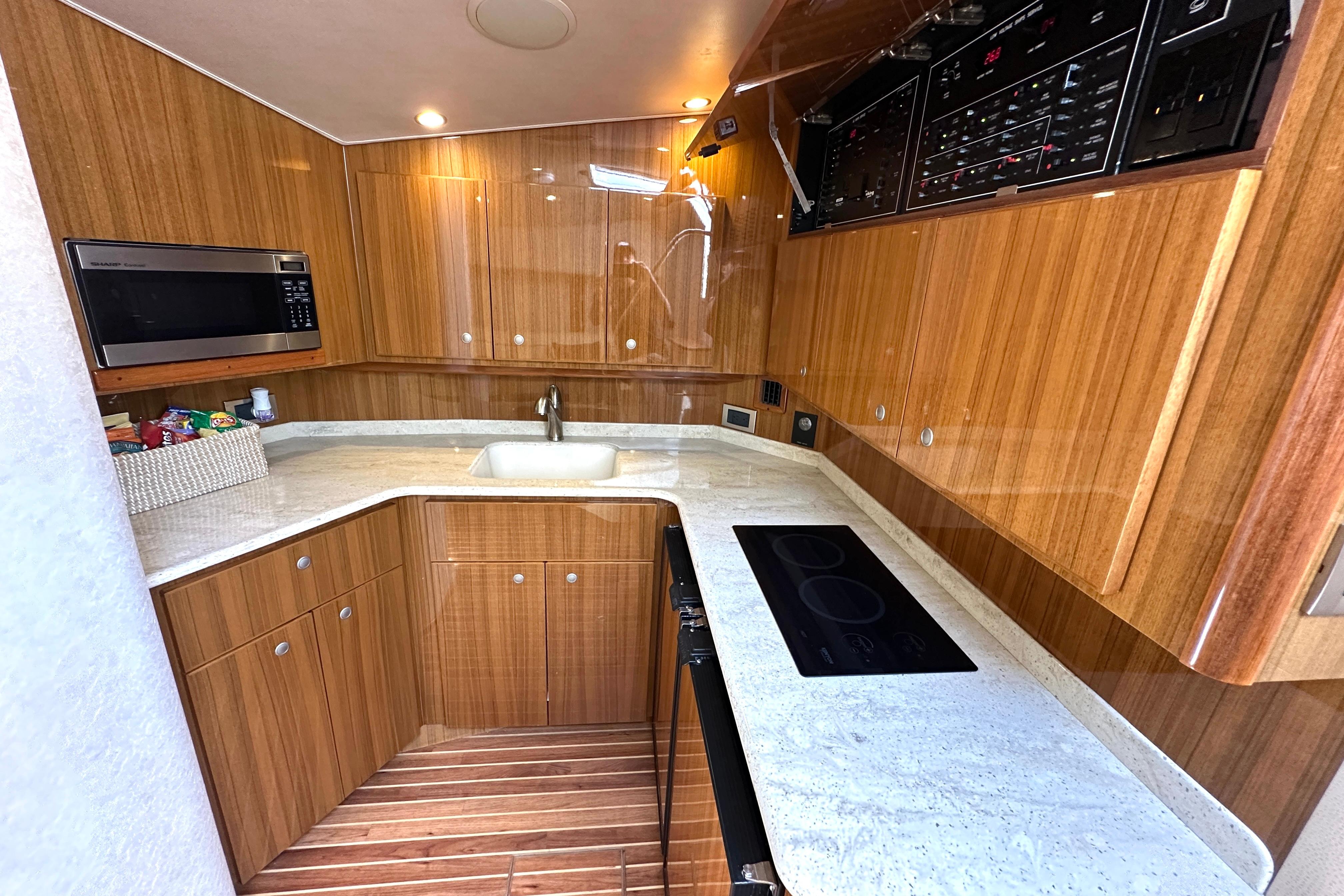Luxurious 2012 Viking 42 Open yacht kitchen with wood cabinetry and modern appliances.