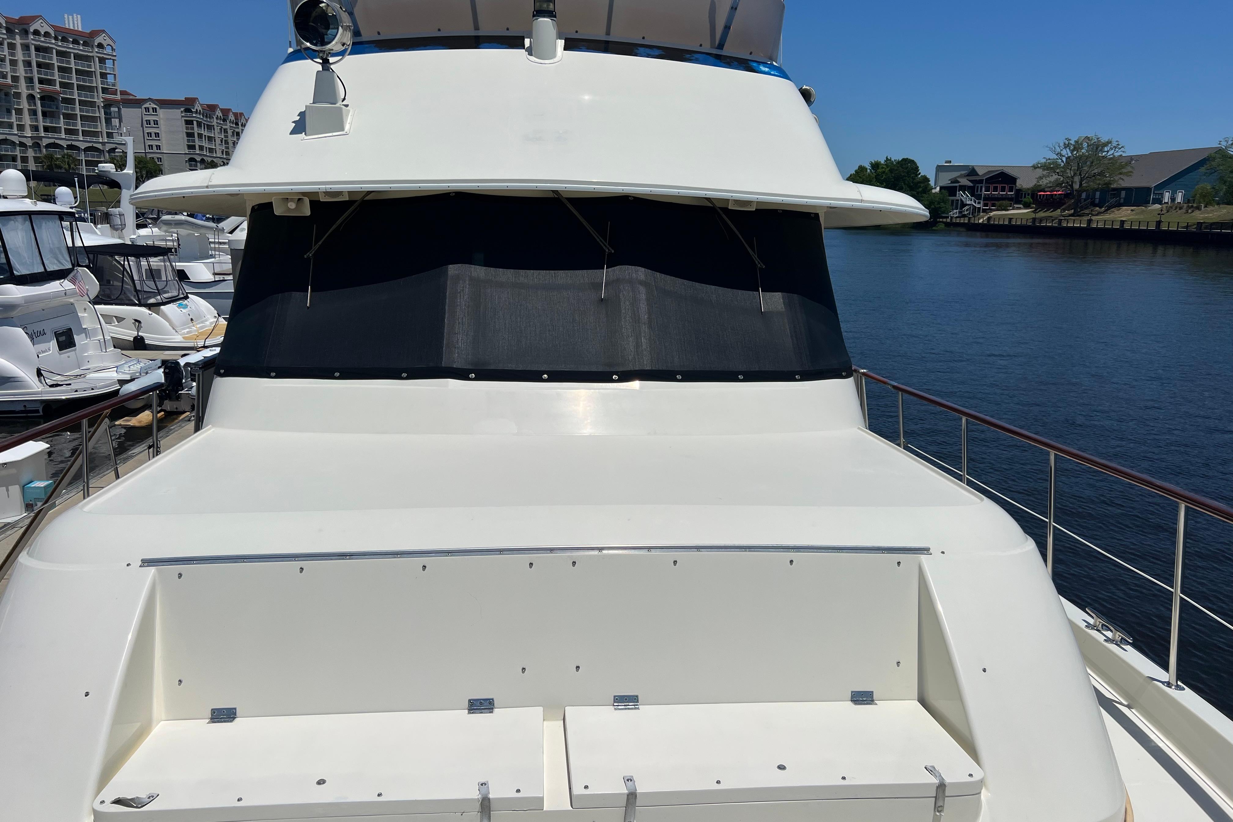 1987 Hatteras 70 Cockpit Motor Yacht docked at marina, sunny day.