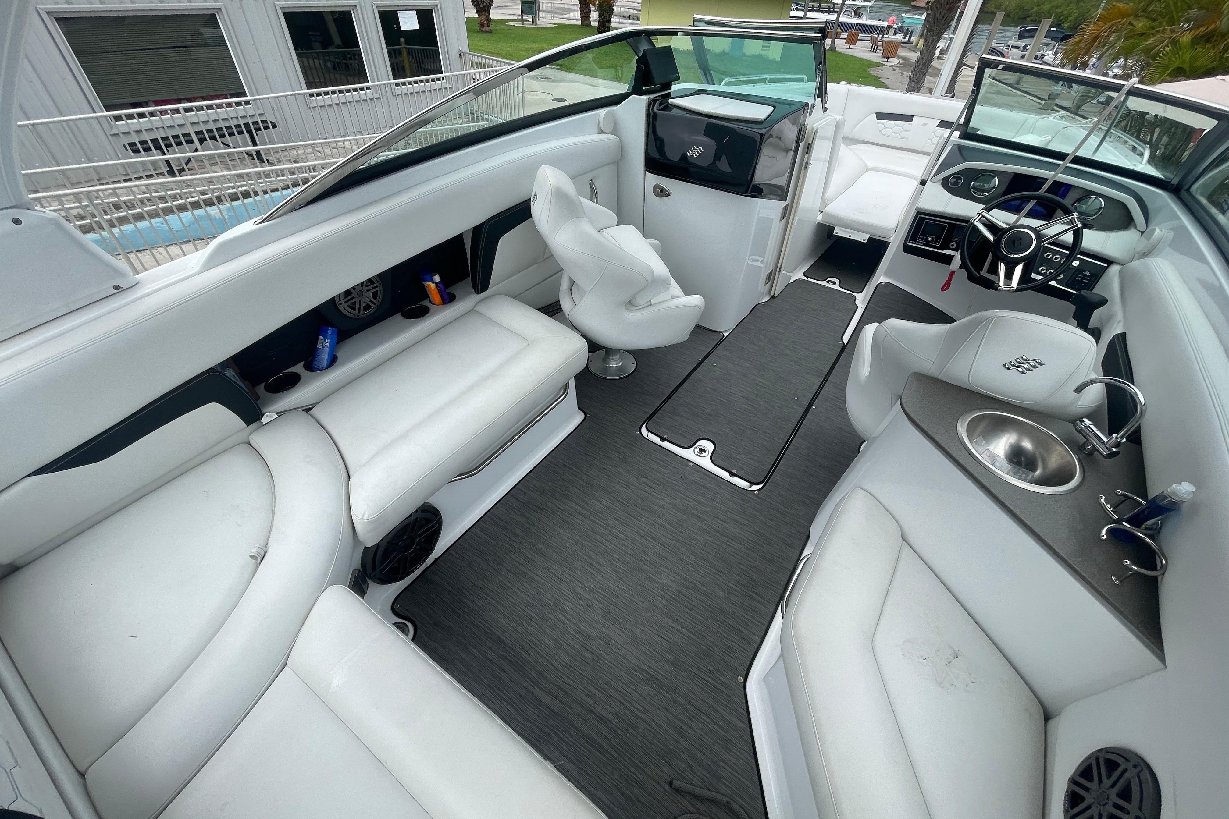 2022 Four Winns HD8 OB boat interior with white seating, steering wheel, and sink.