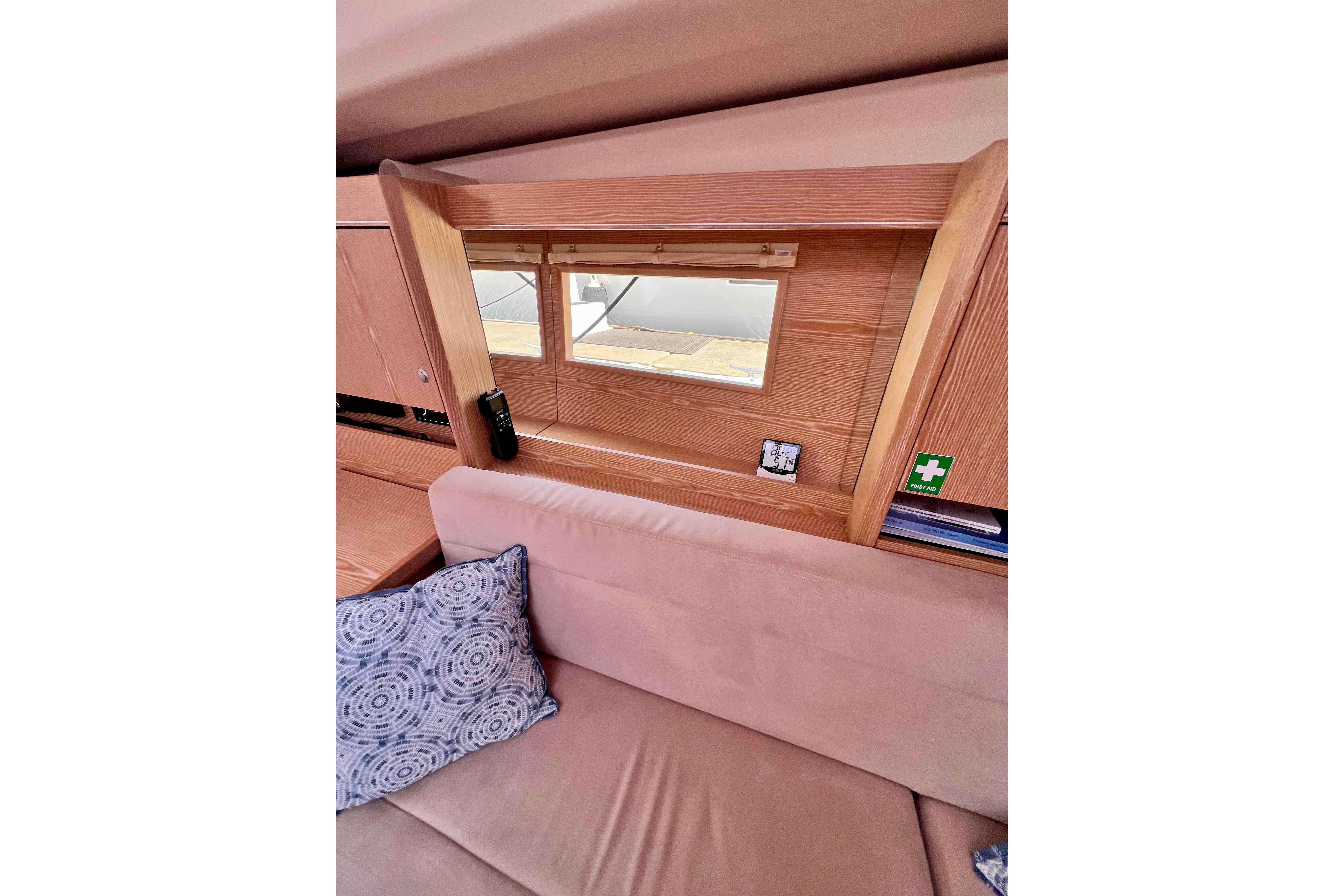 Interior of 2016 Hanse 455 yacht with wooden paneling and cozy seating area.