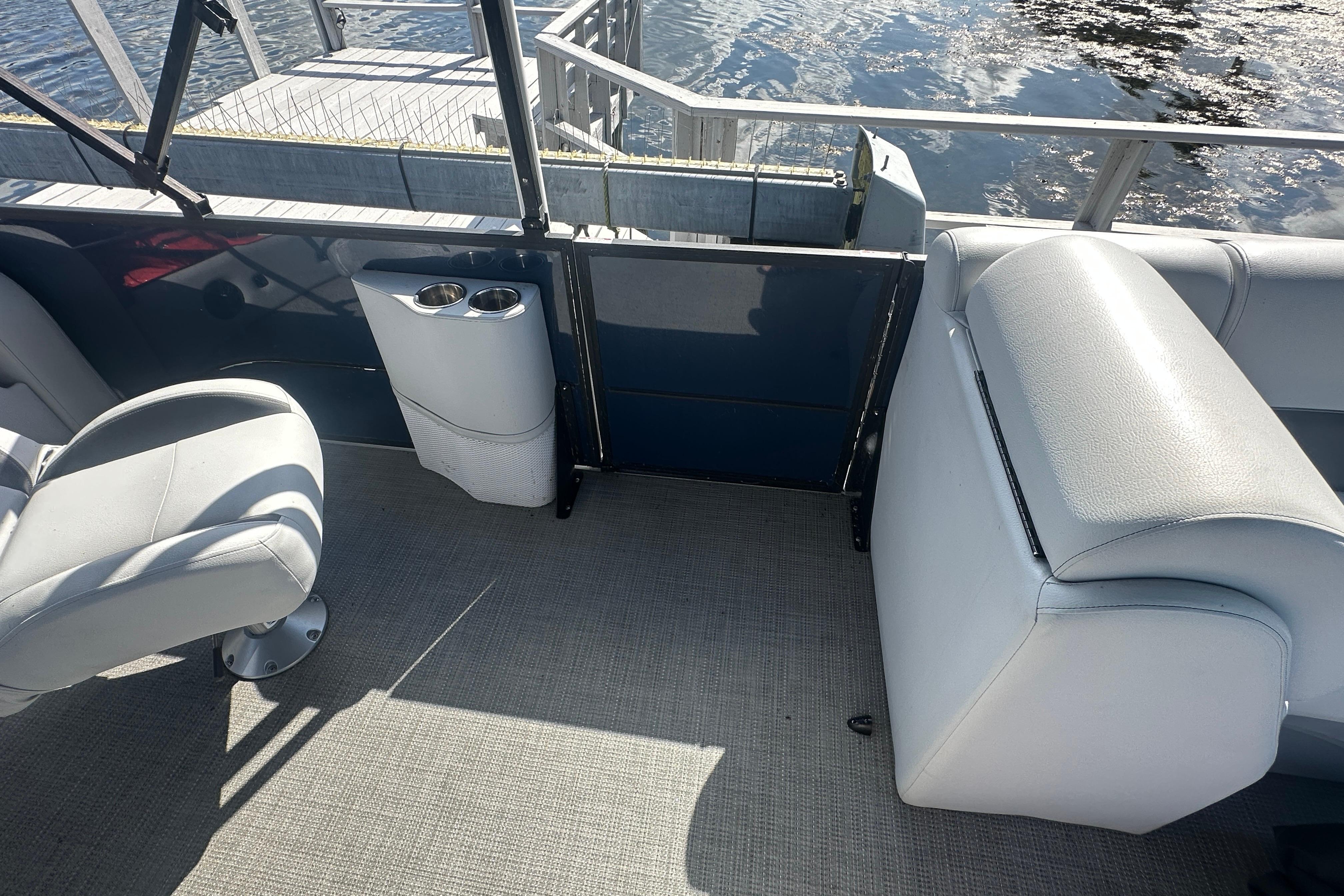 2023 Bentley Pontoons Legacy 243 Swingback interior with seating and cup holders by the water.