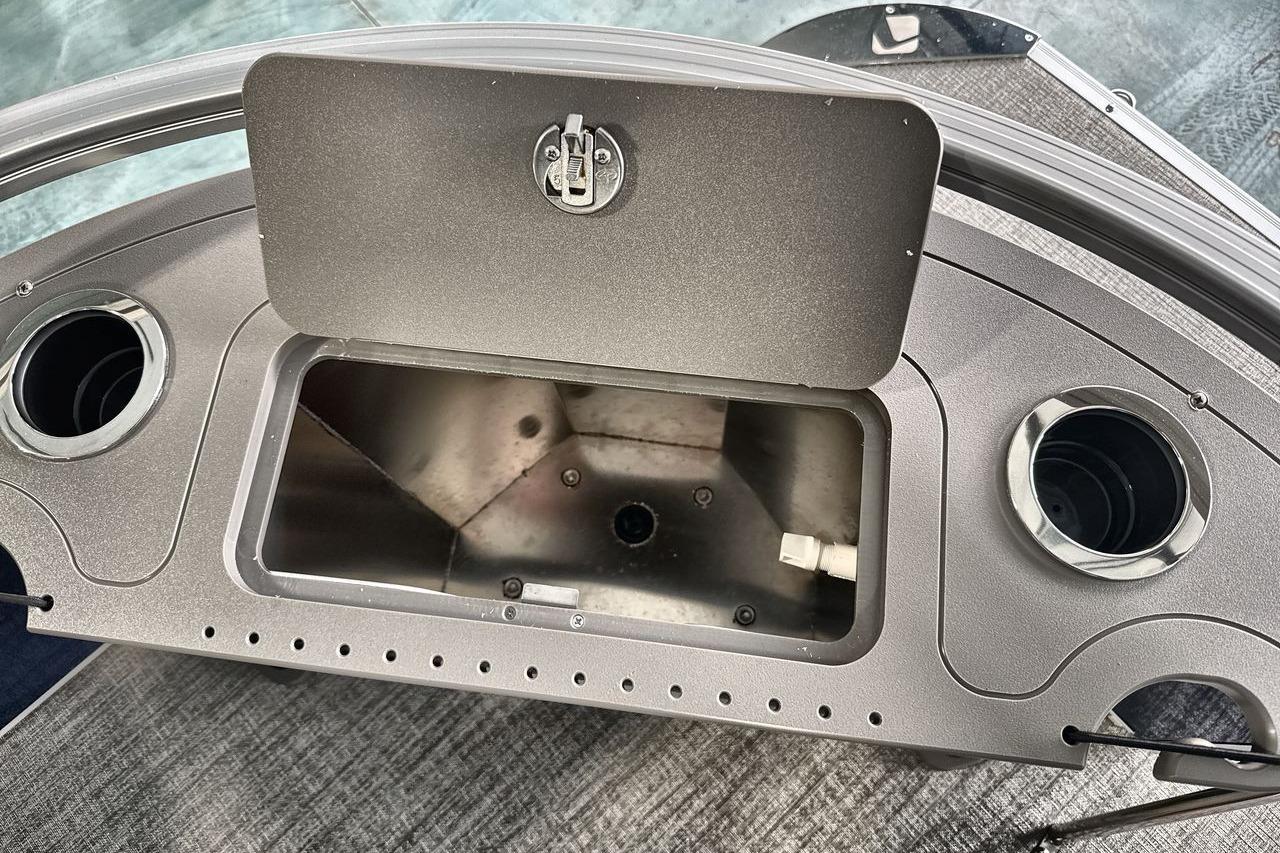 2026 Landau Island Breeze 23F boat console with storage compartment and cup holders.