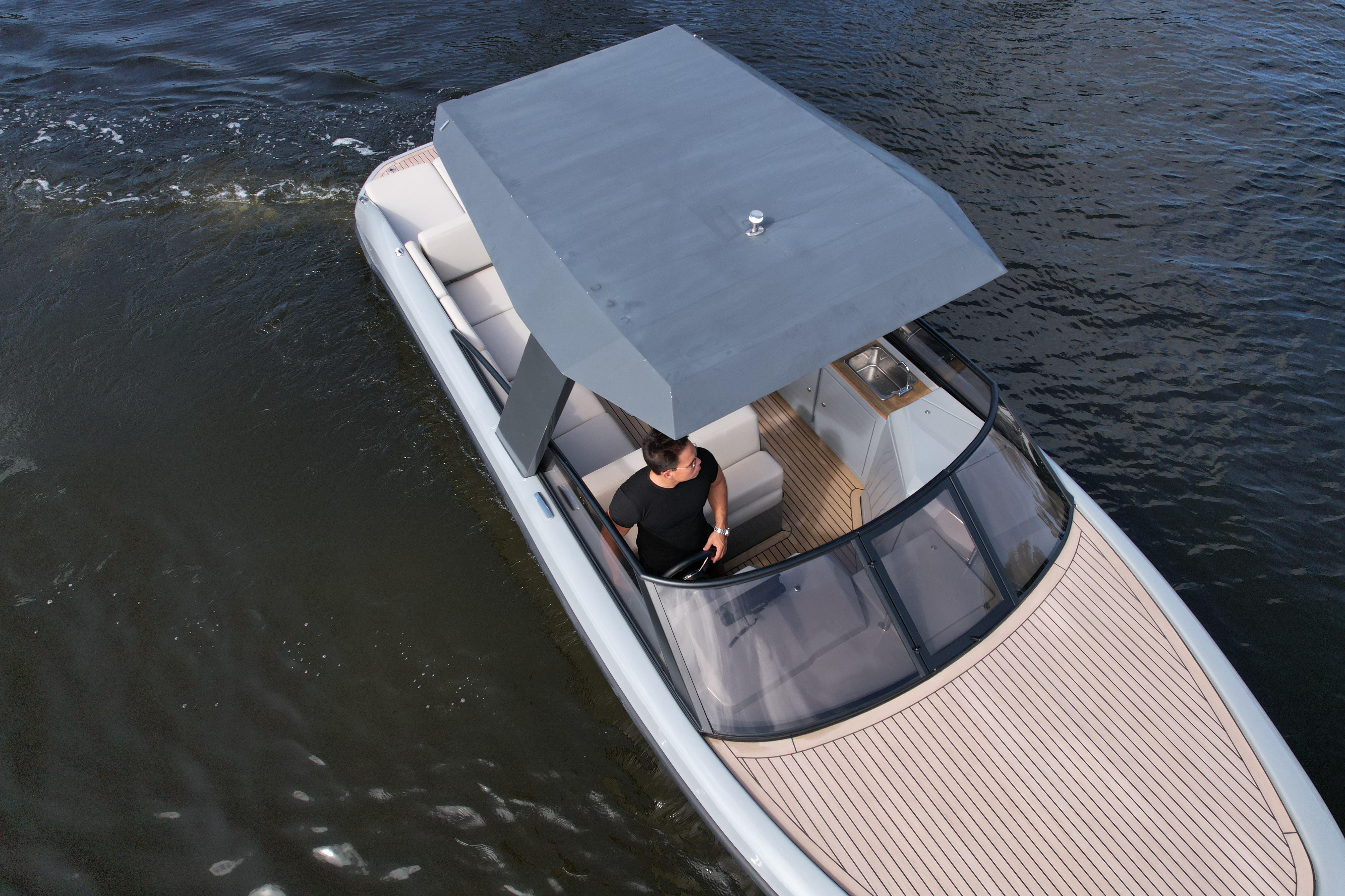 2021 Rand Leisure boat cruising on water with a canopy and seating area.