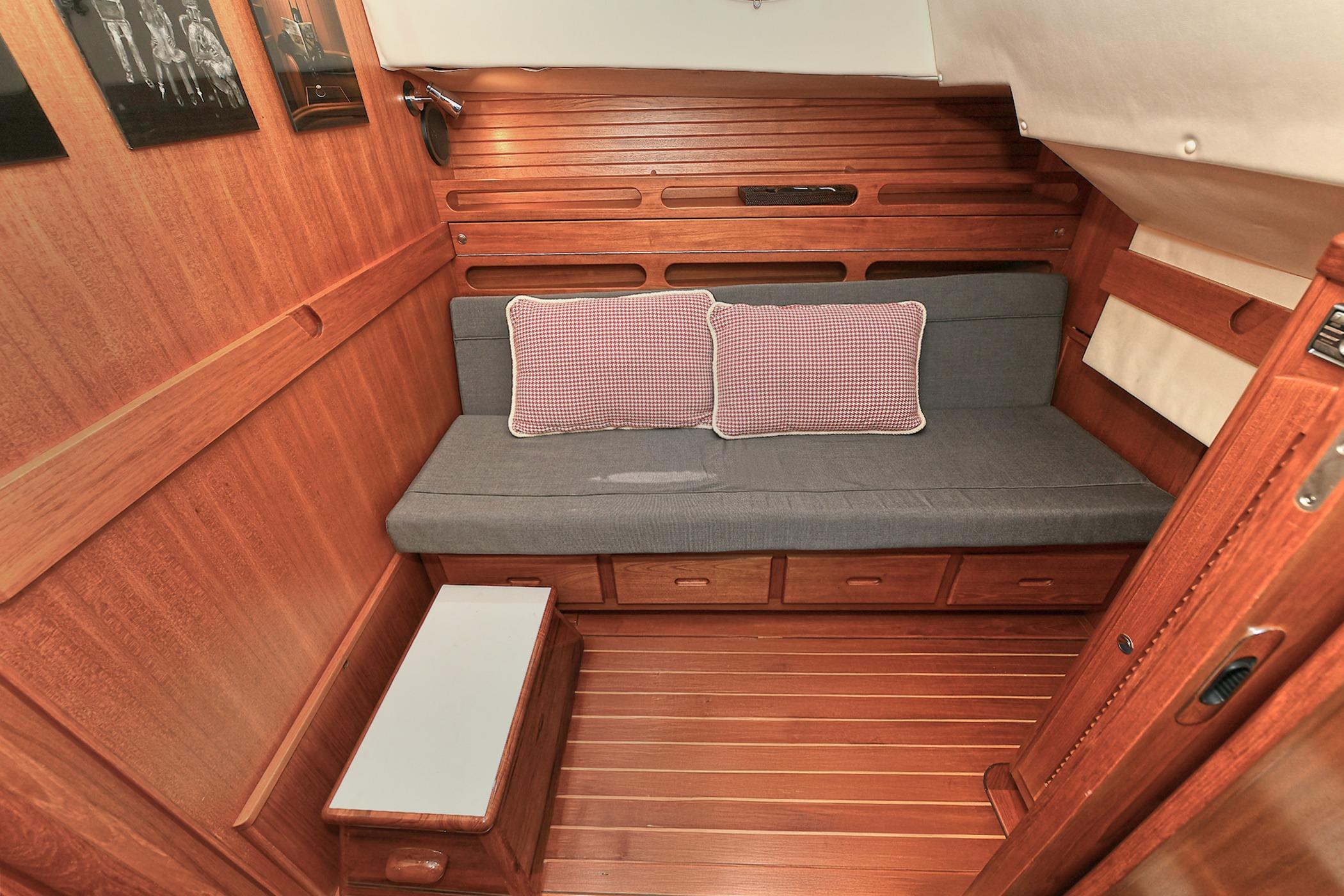 Cozy wooden interior of 2005 San Juan Downeast Express with cushioned seating and storage.
