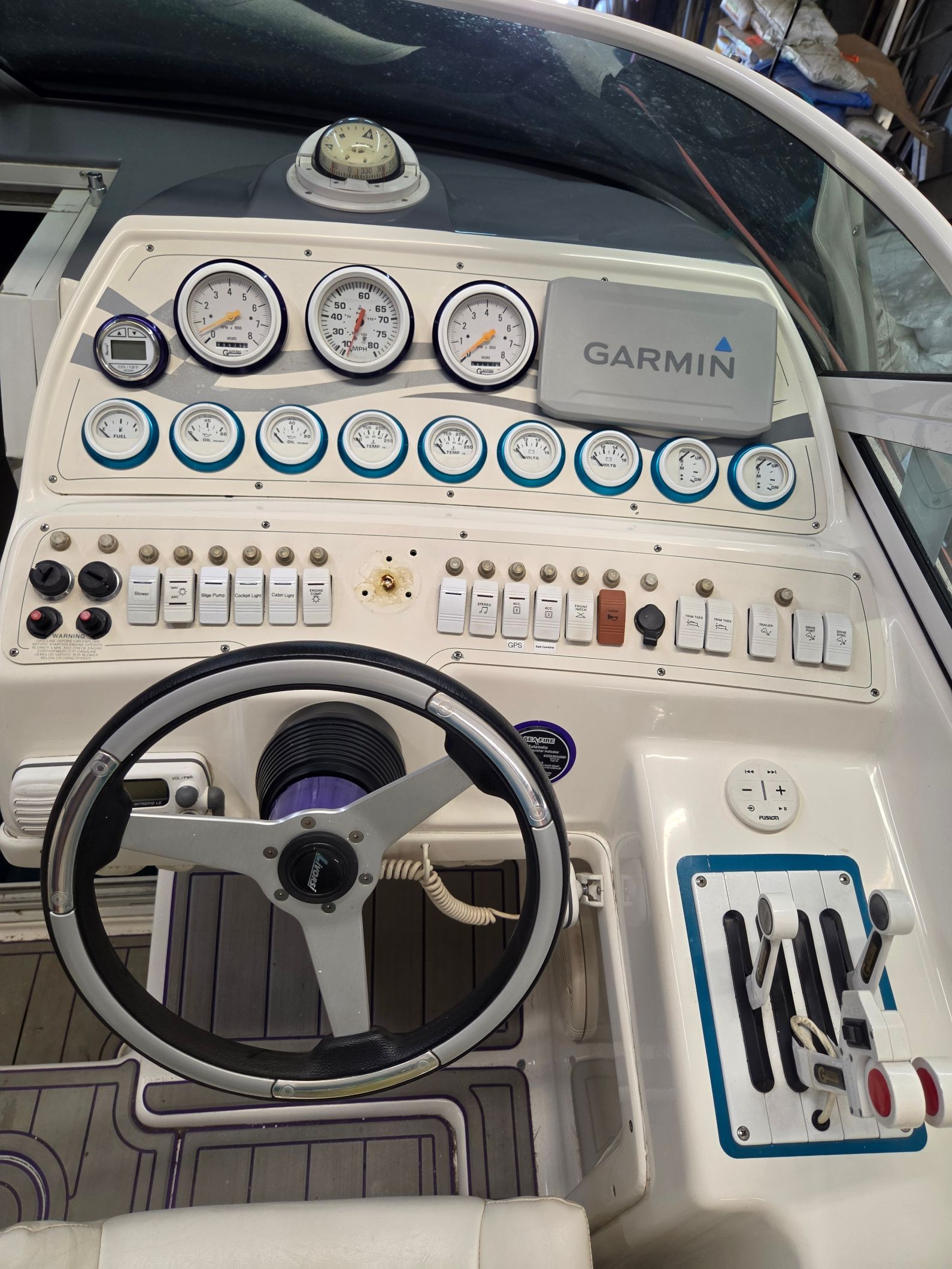 The image shows the helm of a 1998 Powerquest Enticer 290 FX with various gauges and a Garmin device.