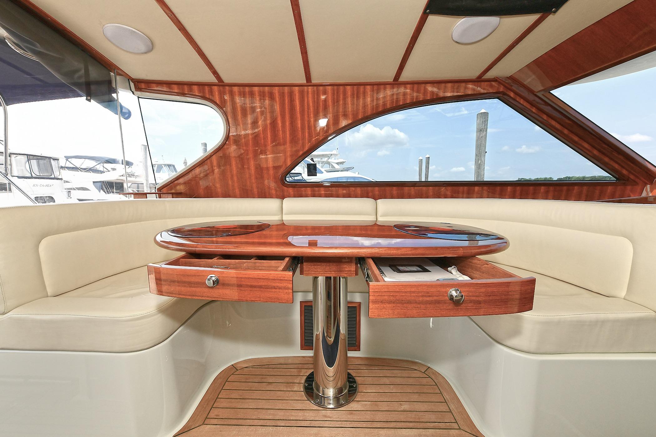 Luxurious 2005 San Juan Downeast Express yacht interior with elegant wood table and seating.