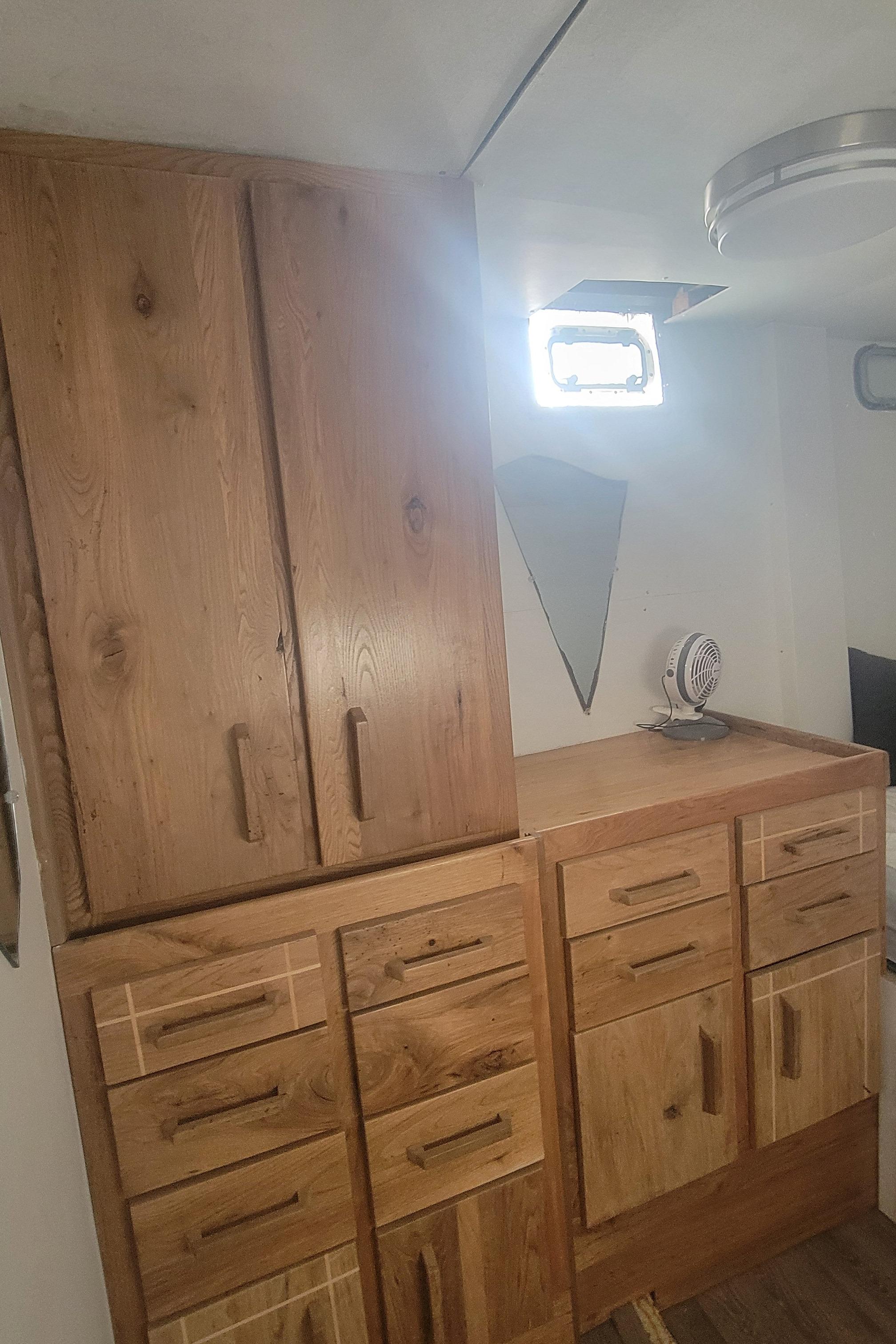 Wooden cabinetry inside a 1979 Shrimper Conversion Trawler, featuring ample storage and natural light.