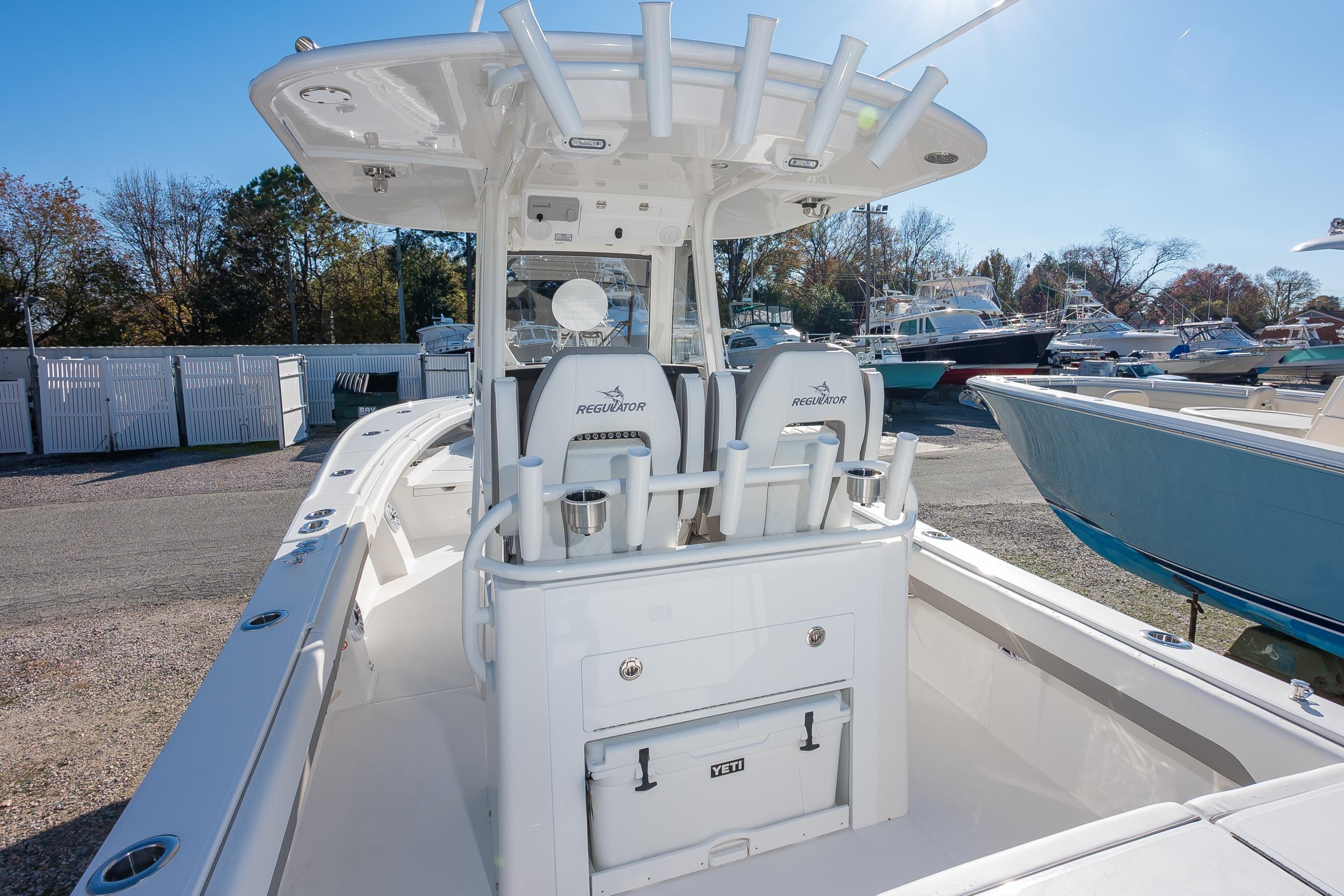 2026 Regulator 28 boat with center console and rod holders, docked in a marina.