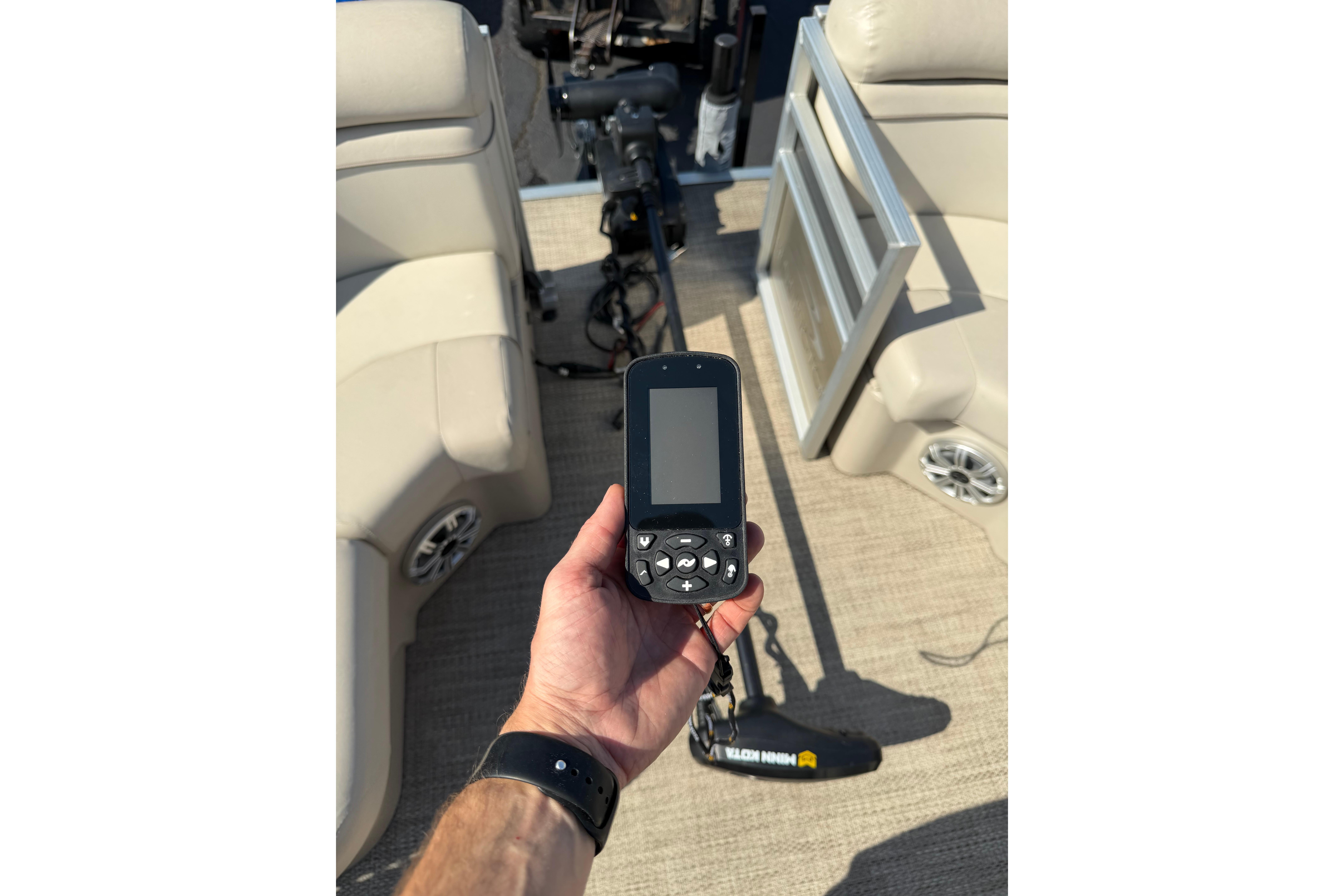Hand holding a GPS device on a 2018 Bennington 21 SF boat deck.