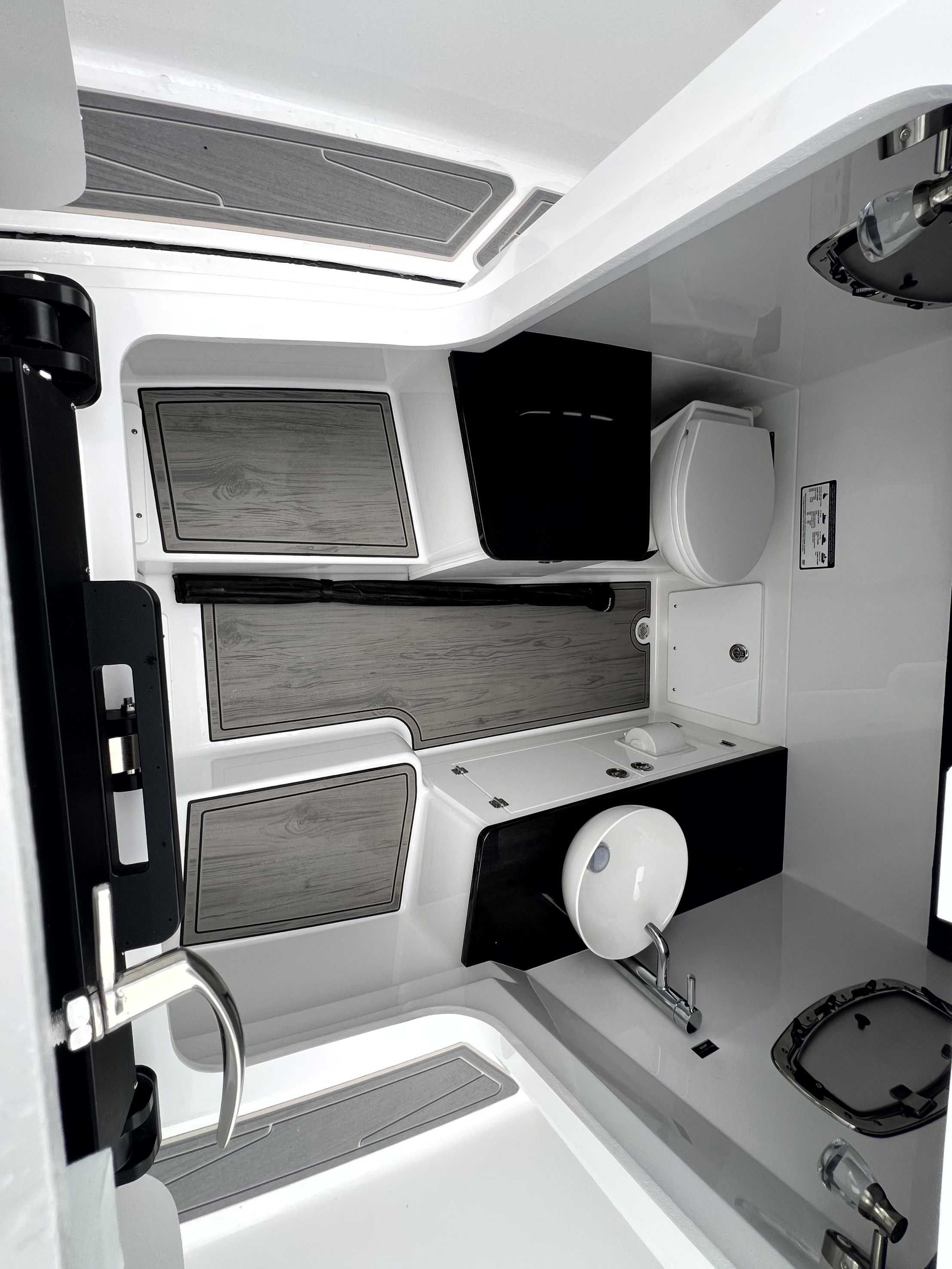 Interior of a modern boat cabin with a sink, toilet, and stylish finishes.