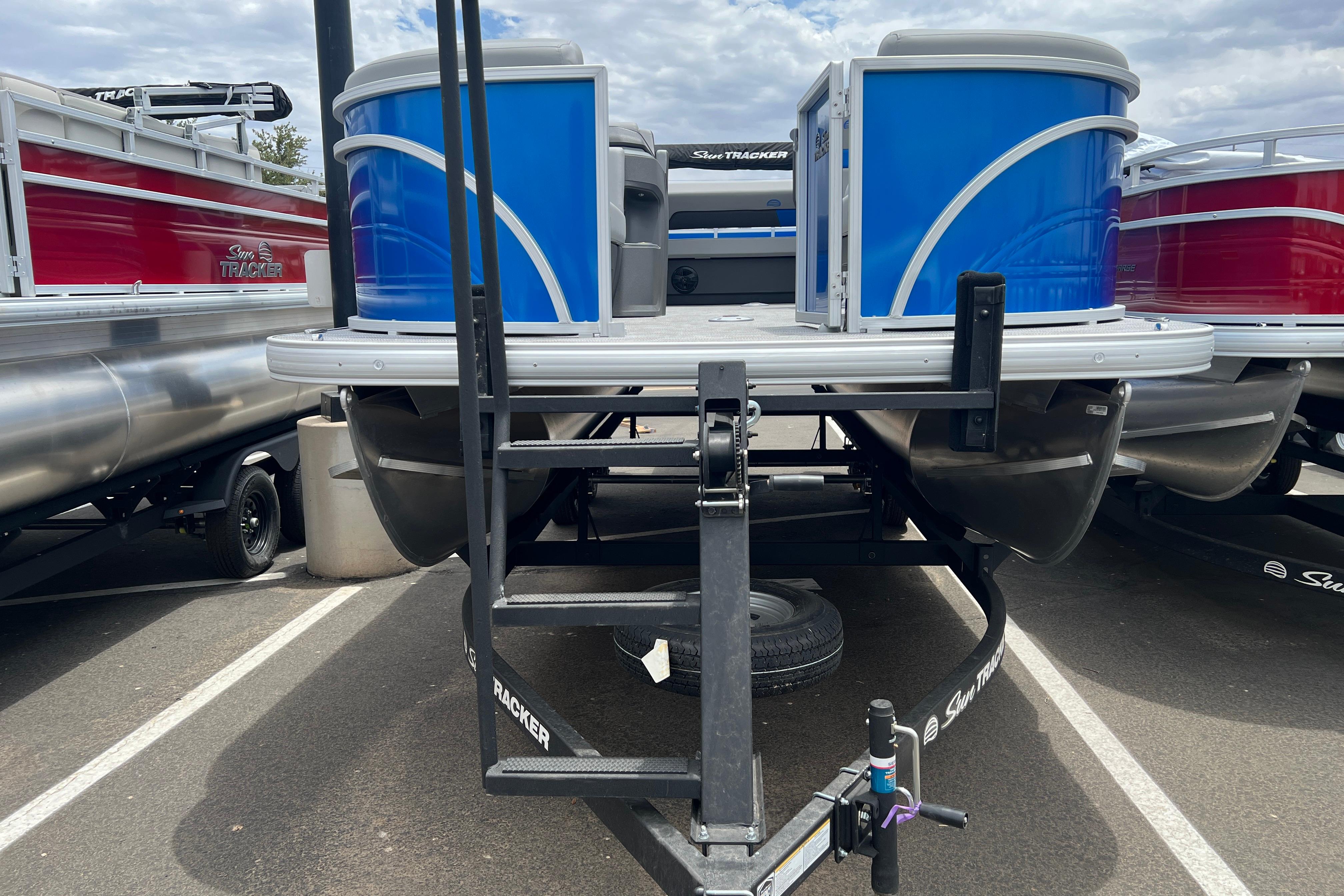 2026 Sun Tracker Party Barge 22 RF DLX pontoon boat on trailer, blue exterior.