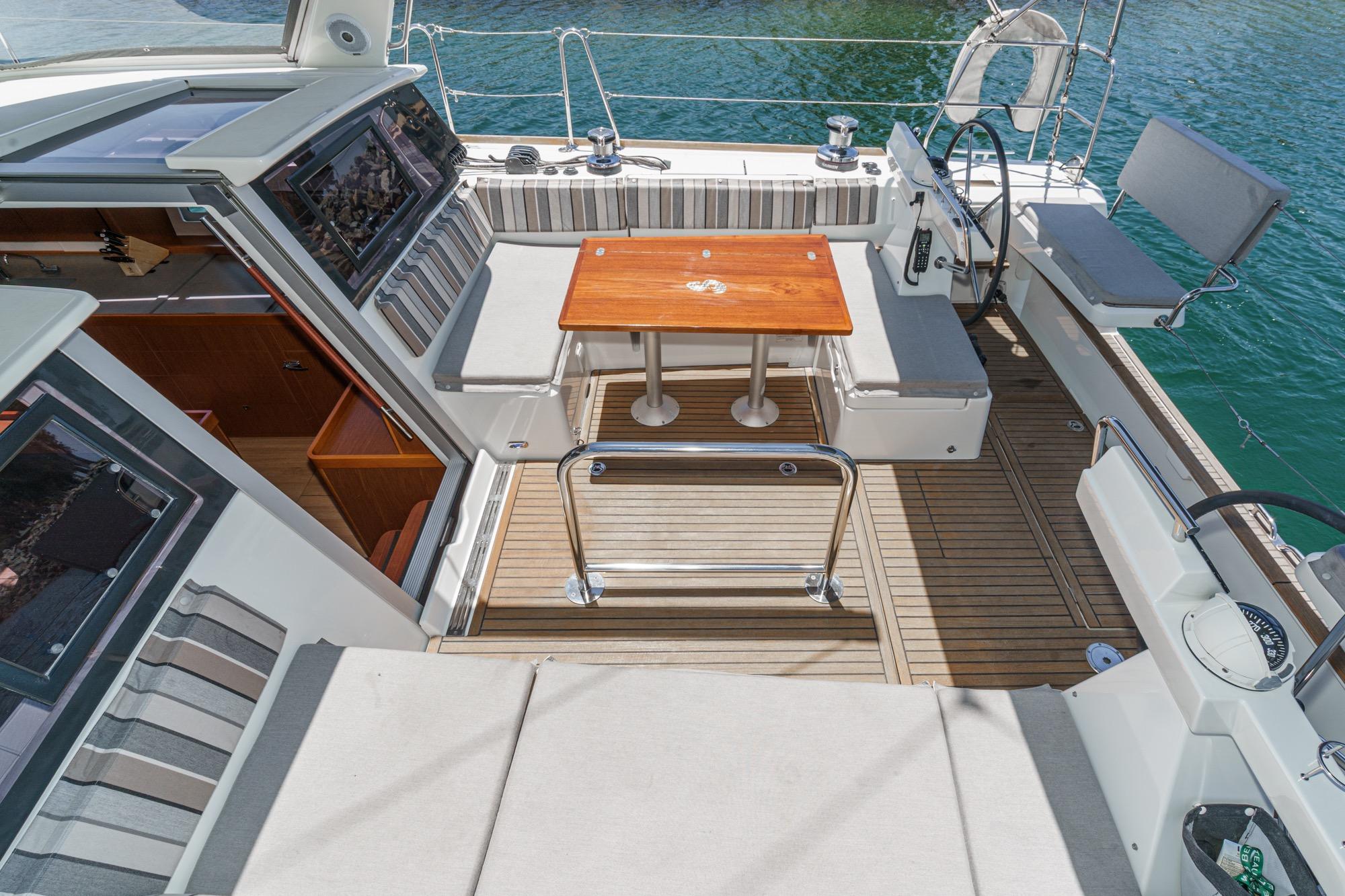 Luxurious 2017 Beneteau Sense 50 yacht cockpit with wooden table and seating.