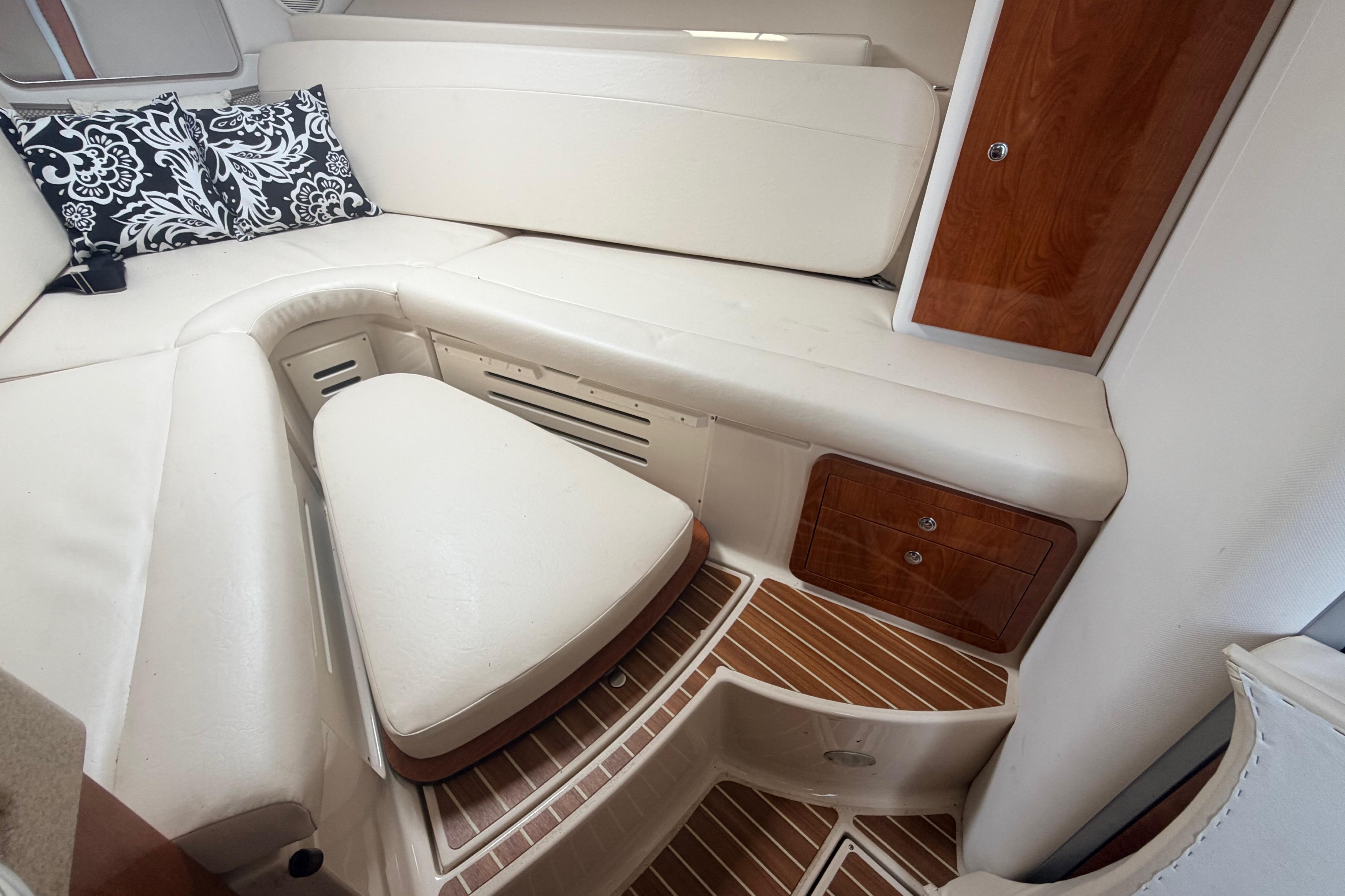 2015 Wellcraft 290 Coastal cabin interior with white seating and wooden accents.