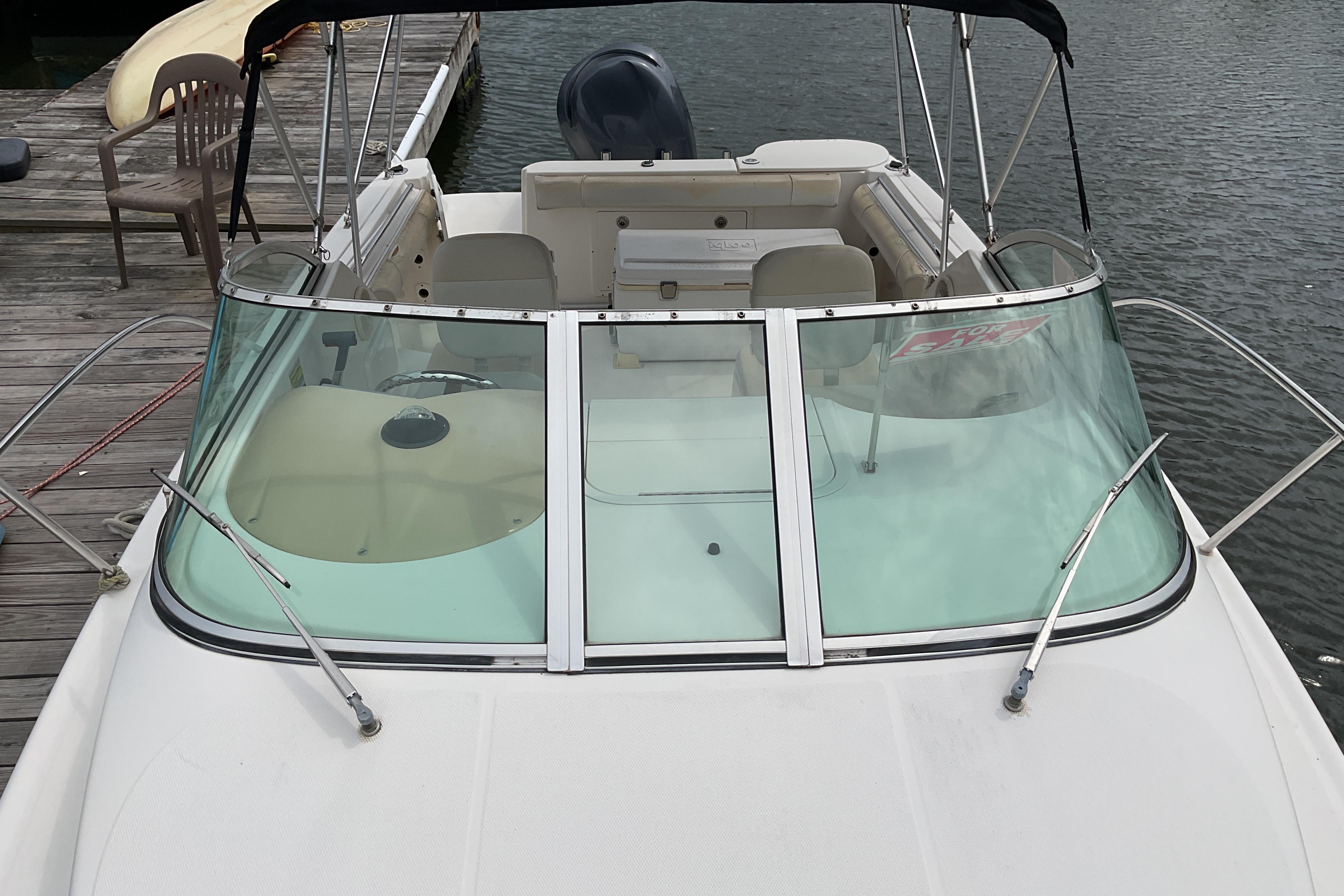 2012 Wellcraft 232 Coastal boat docked, featuring windshield and seating area.